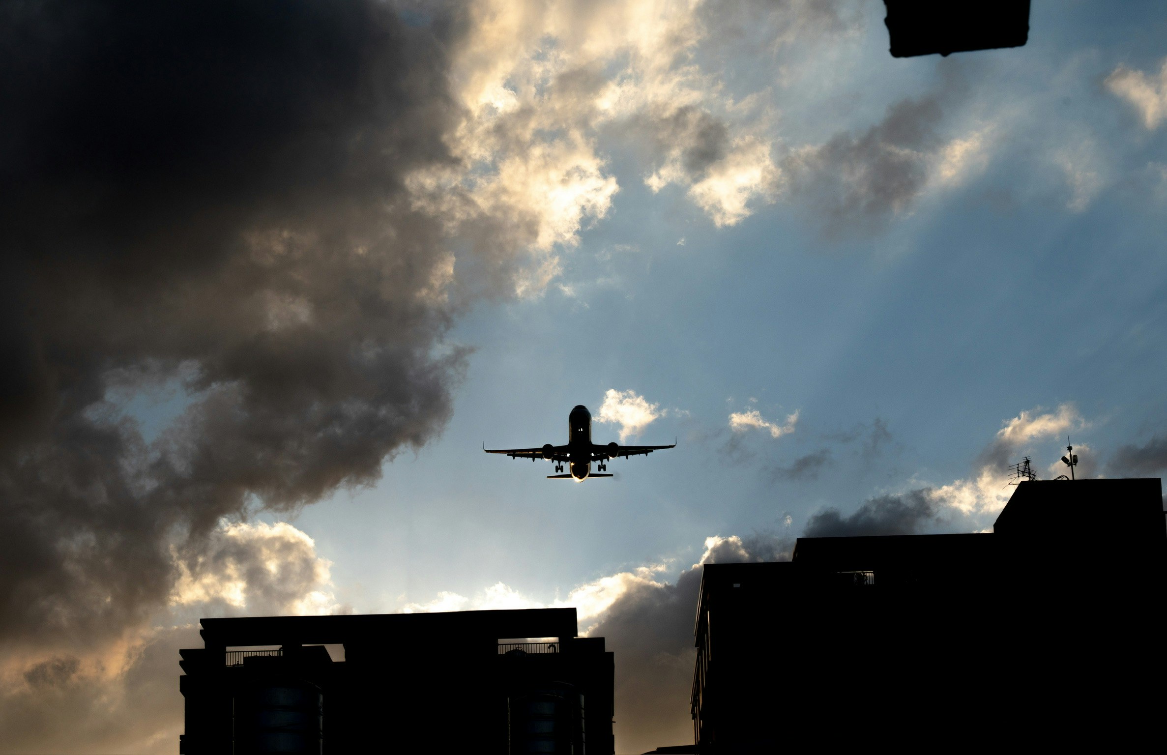 飛行機が雲の中を飛んでいるシルエットの画像