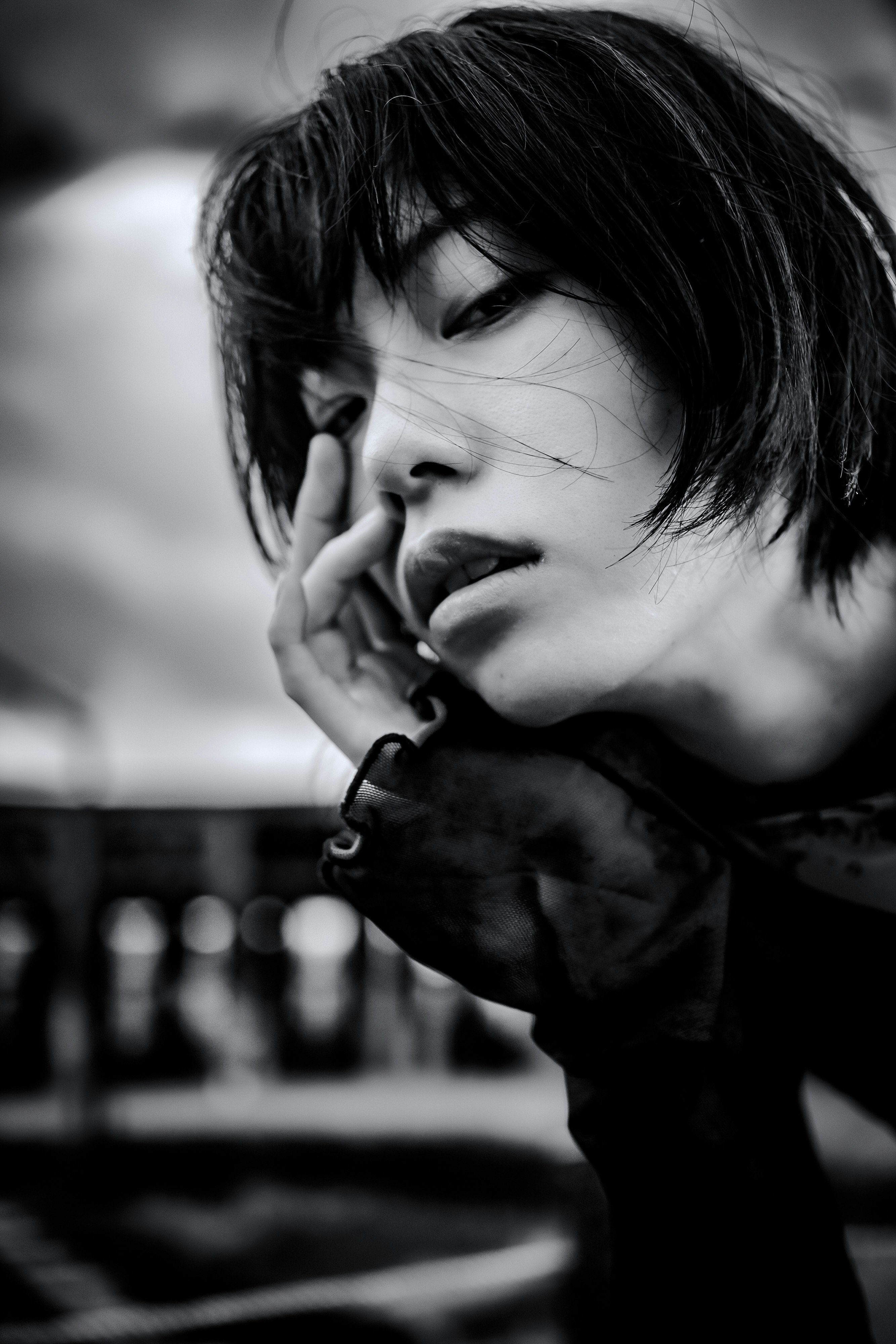 Black and white photo of a woman resting her face on her hand with a pensive expression