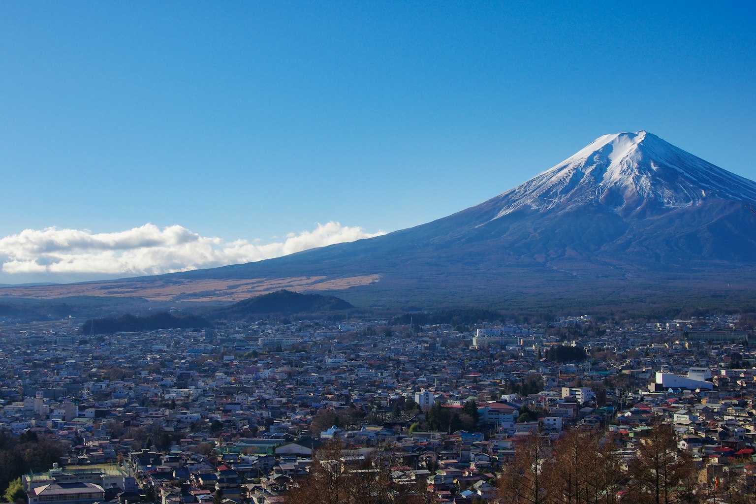 富士山的壯麗景色，清澈的藍天和下面延伸的城市