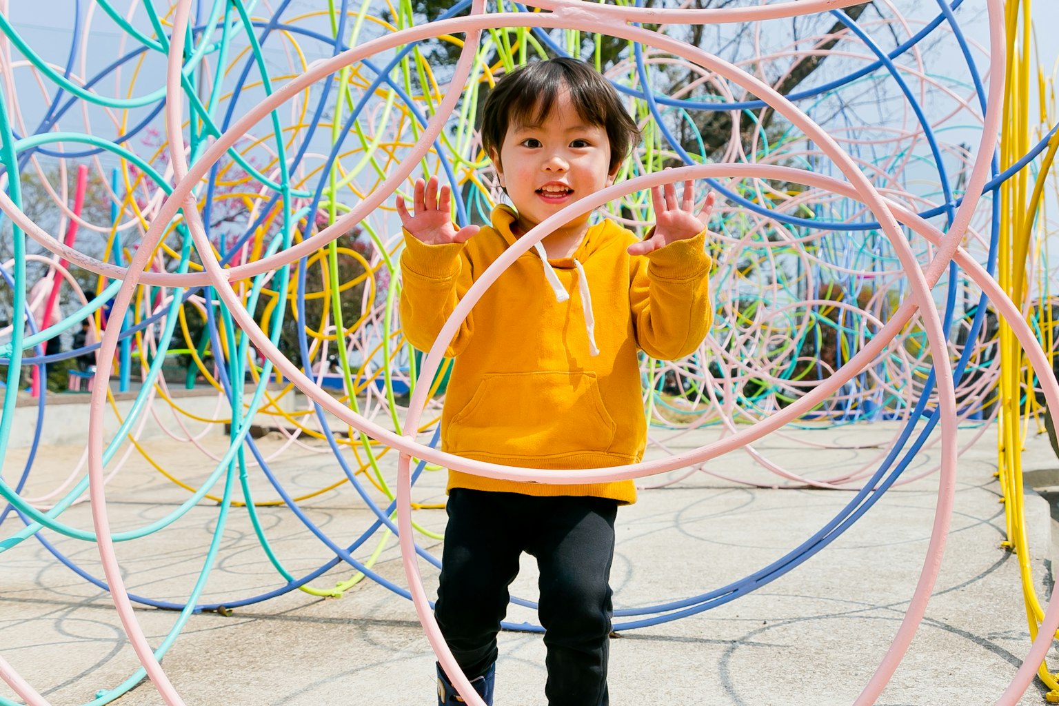 Bambino in un'area giochi colorata circondato da anelli