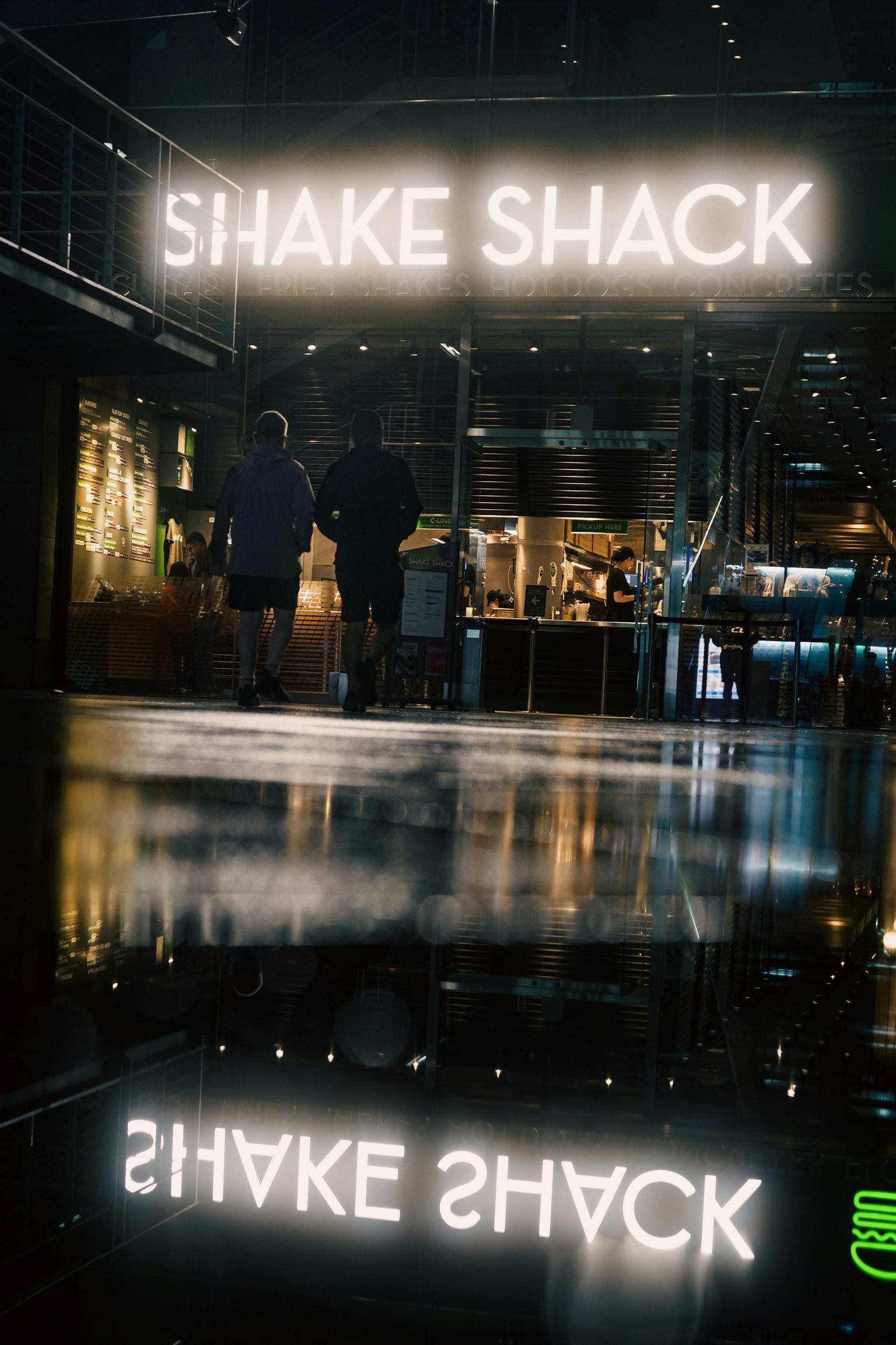 มุมมองภายในที่มีป้าย Shake Shack สว่างและการสะท้อน