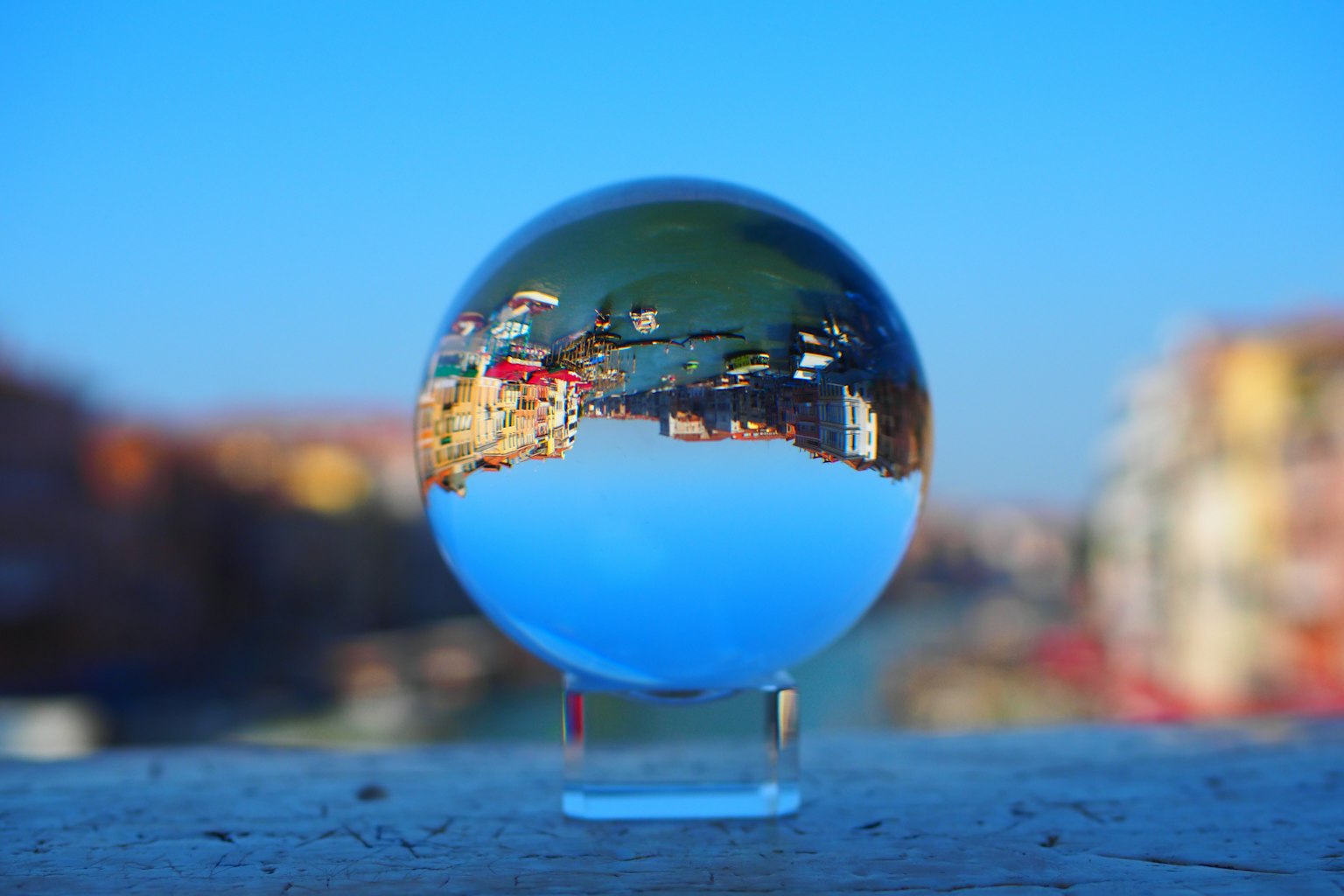 Una sfera di cristallo che riflette un paesaggio urbano con cielo blu