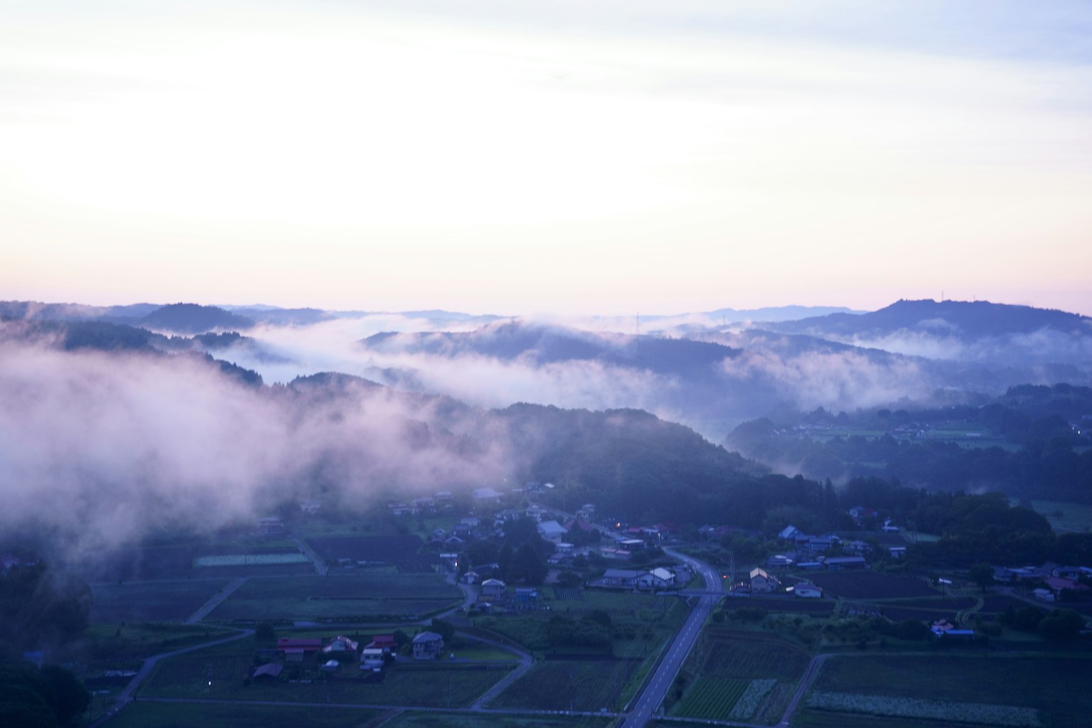 Fog-covered mountains and tranquil village landscape