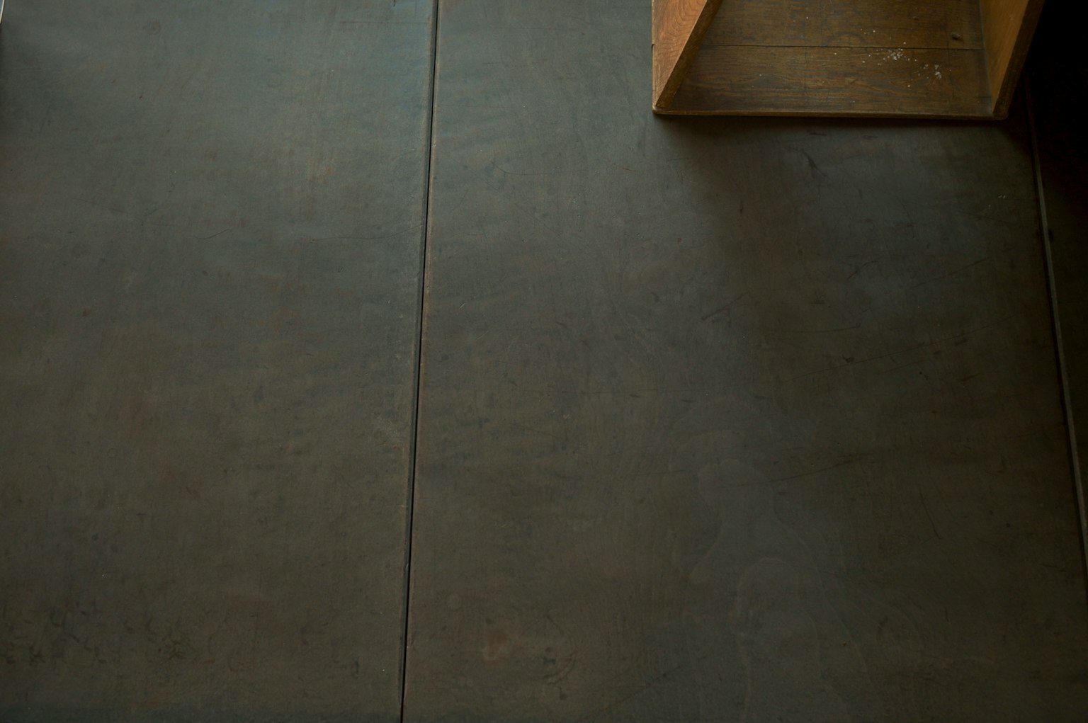 Dark colored floor with a wooden box in a simple interior