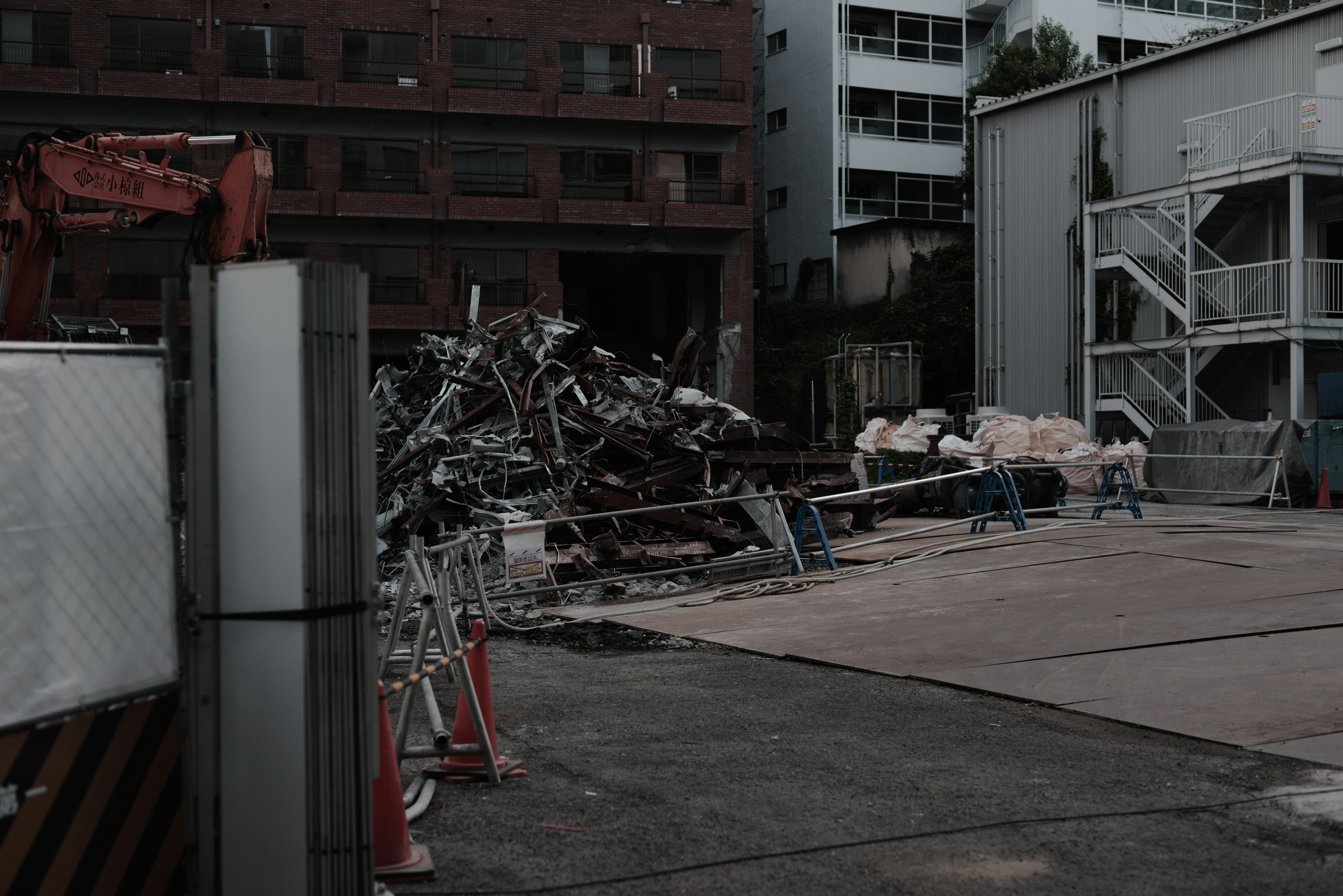 解体工事現場の瓦礫と重機のある都市景観