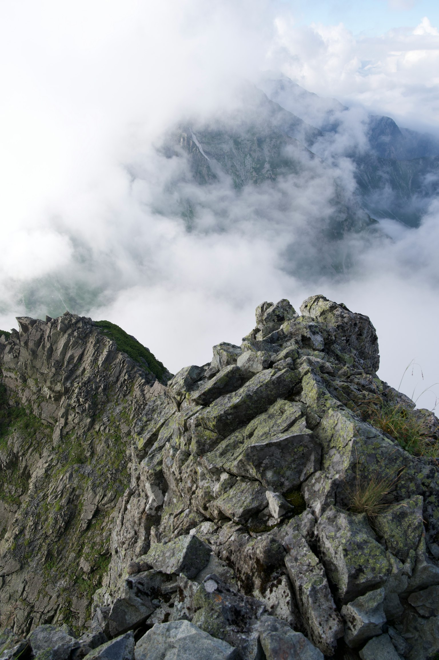 Scenic view from the summit of a rocky mountain above the clouds