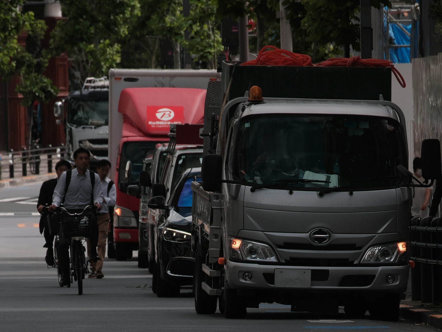 Escena urbana con un ciclista y camiones de entrega aparcados