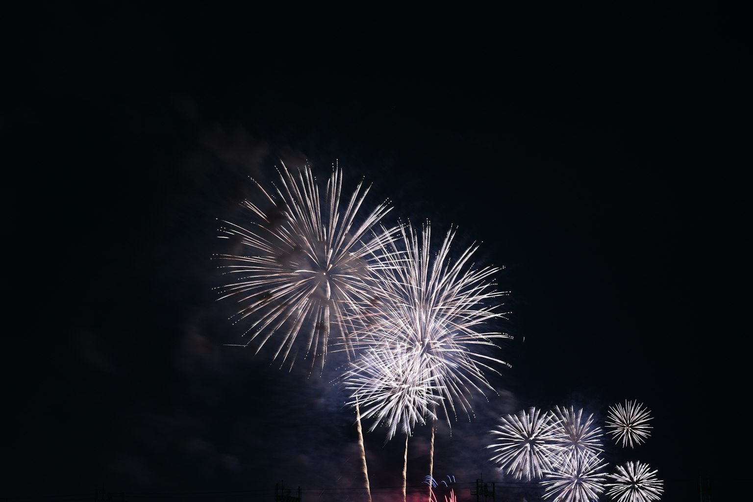 Un gruppo di fuochi d'artificio bianchi brillanti nel cielo notturno