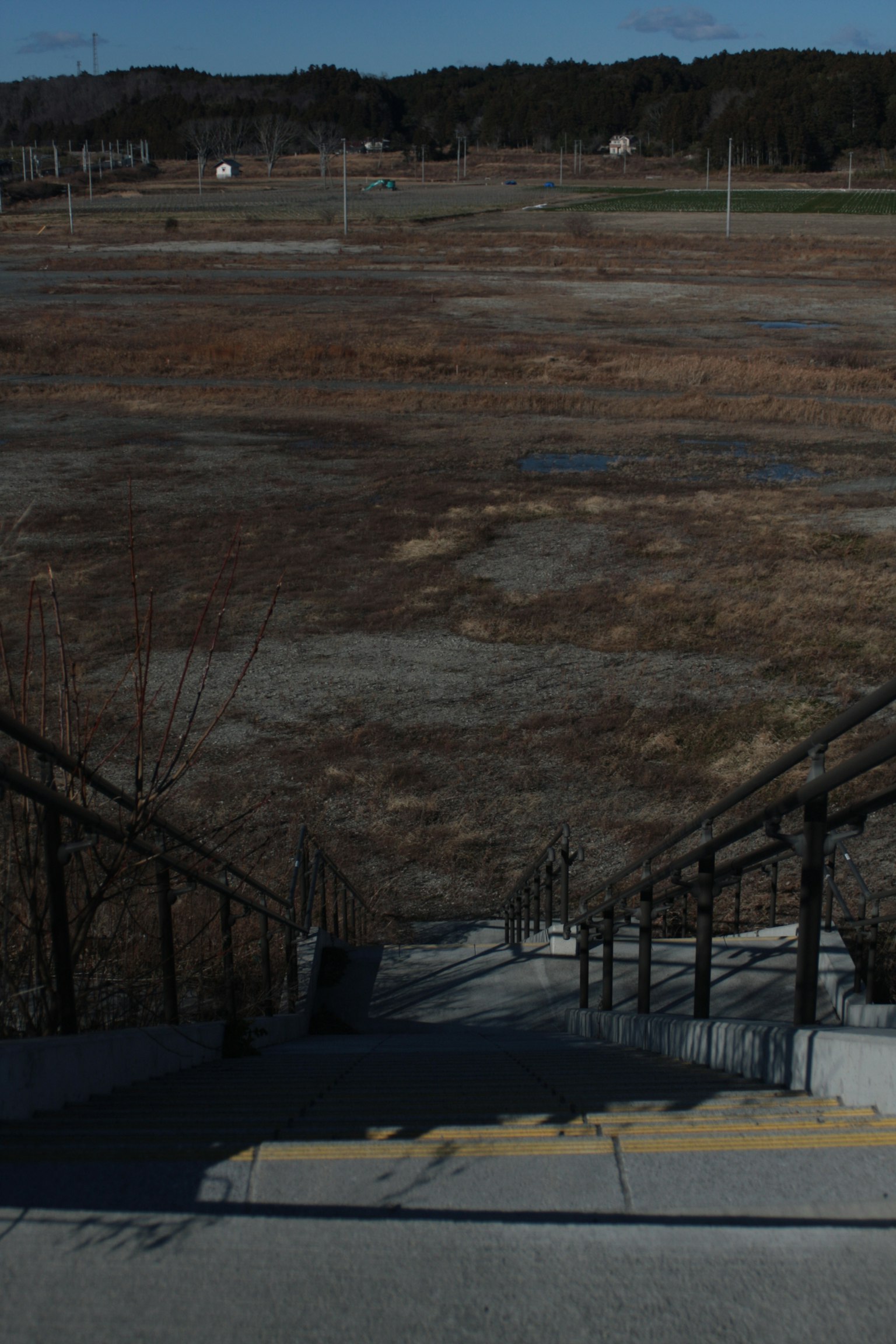 View of an empty field from the perspective of descending stairs