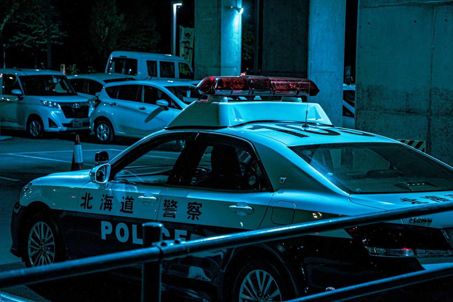 停在藍色燈光下的警車和周圍車輛