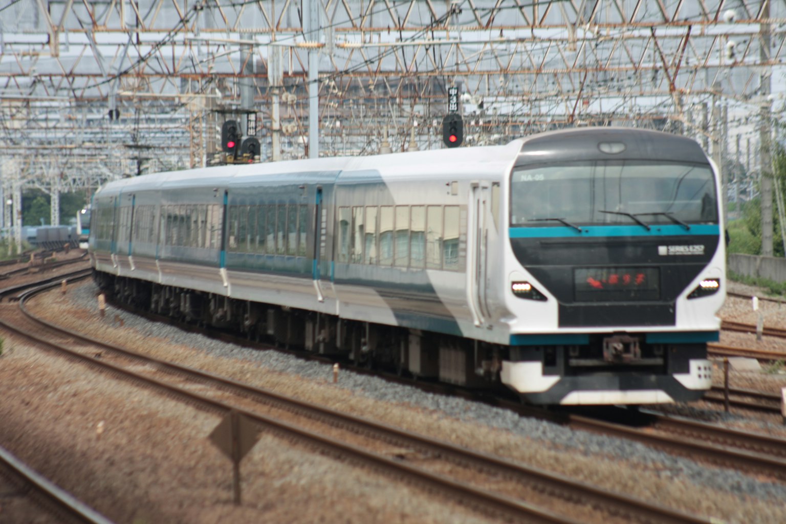 รถไฟสมัยใหม่สีขาวและสีน้ำเงินวิ่งอยู่บนราง