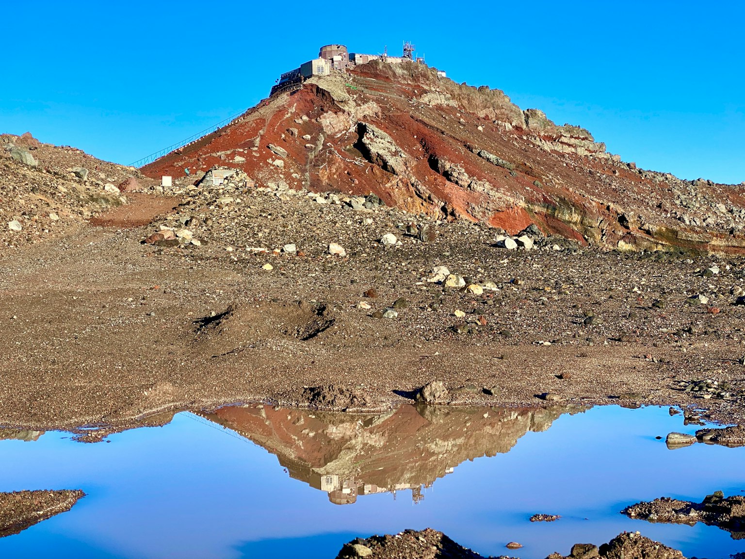 Vista panoramica di una montagna rossa con riflesso in una pozzanghera
