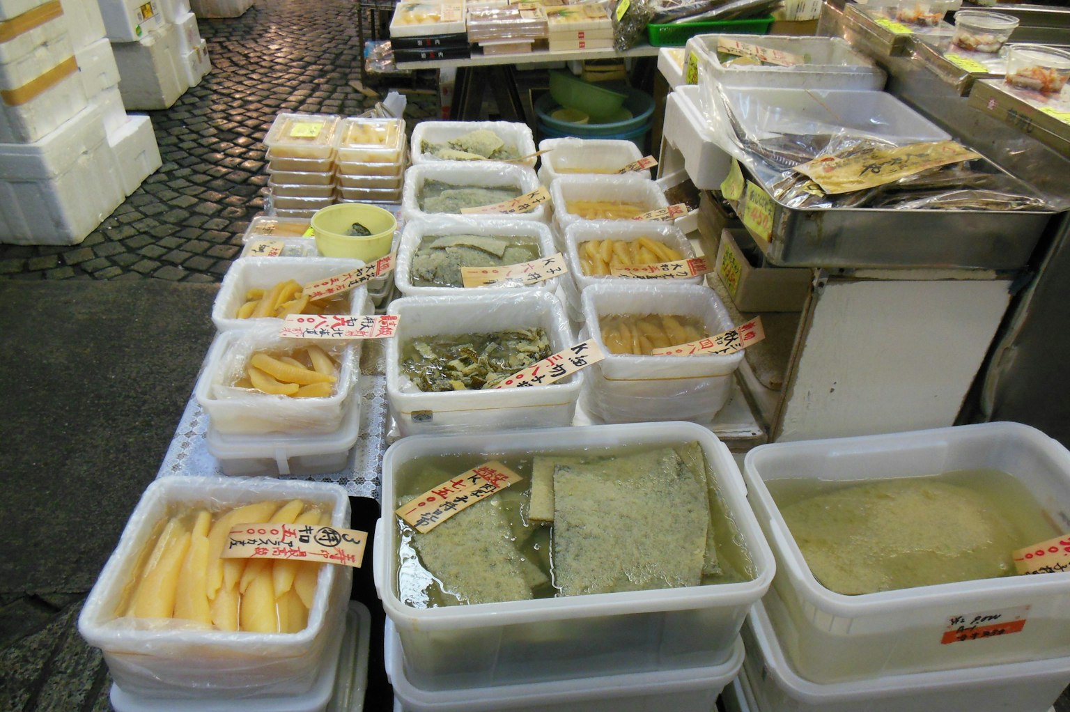 Contenedores transparentes llenos de varios ingredientes en un puesto de mercado