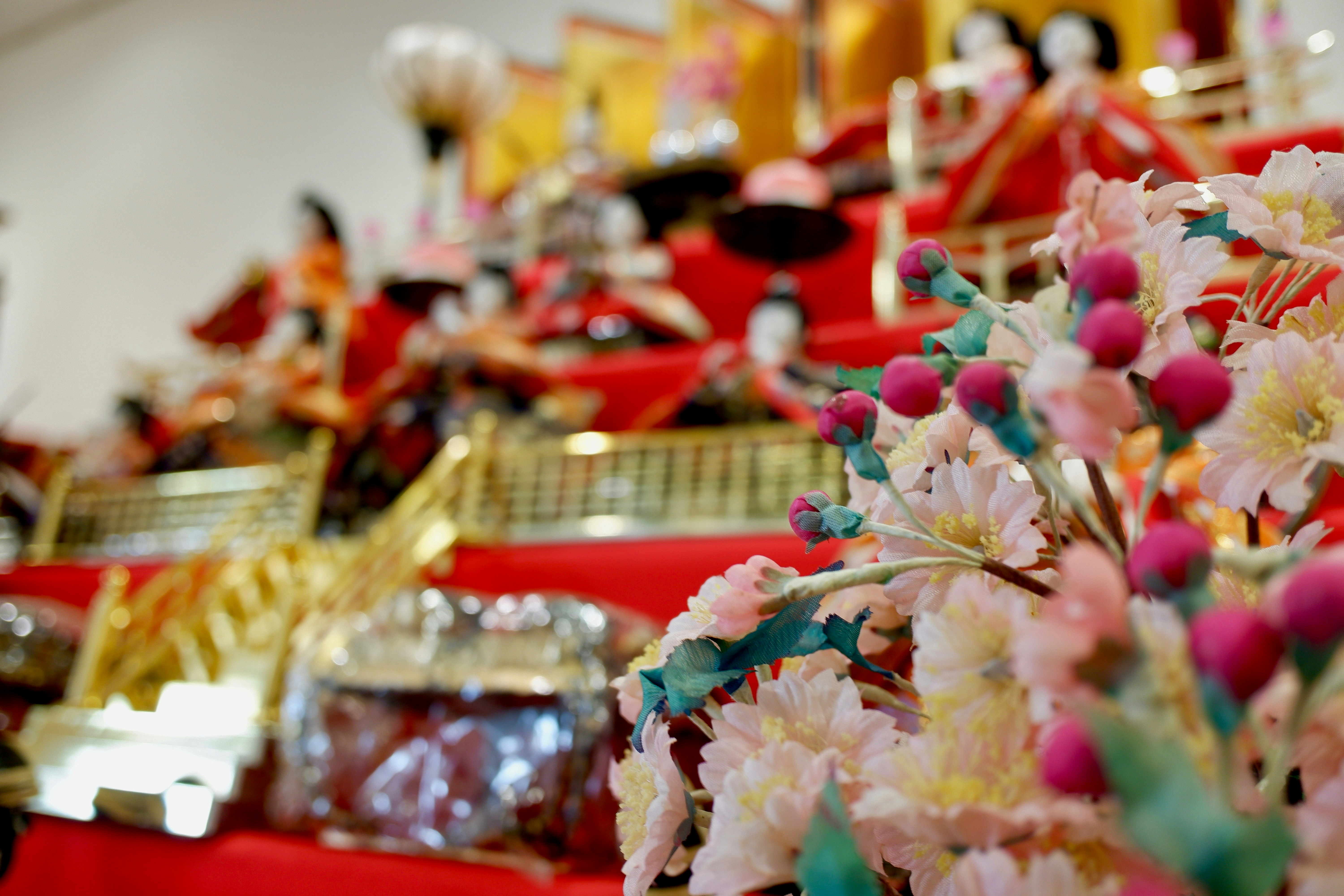 花と赤いテーブルが並ぶ華やかなイベント会場