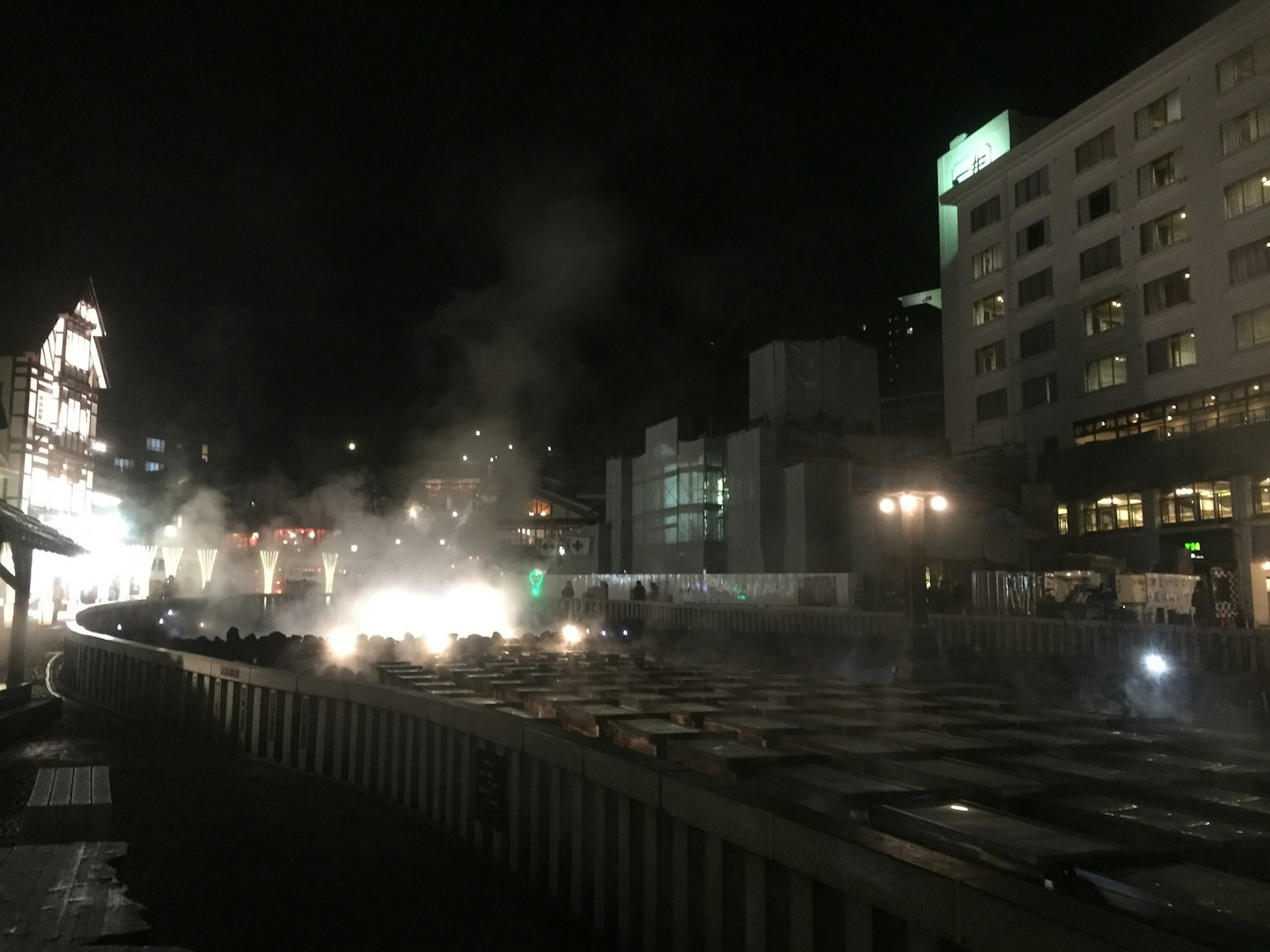Nighttime urban scene featuring smoke and lights
