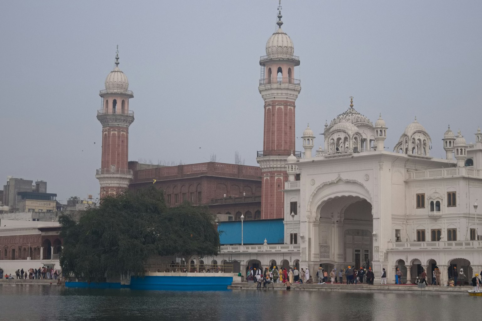 A scenic view of a holy site featuring a beautiful white structure and red towers