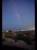 岩場の海岸に並ぶ杭と夜明け前の青い空