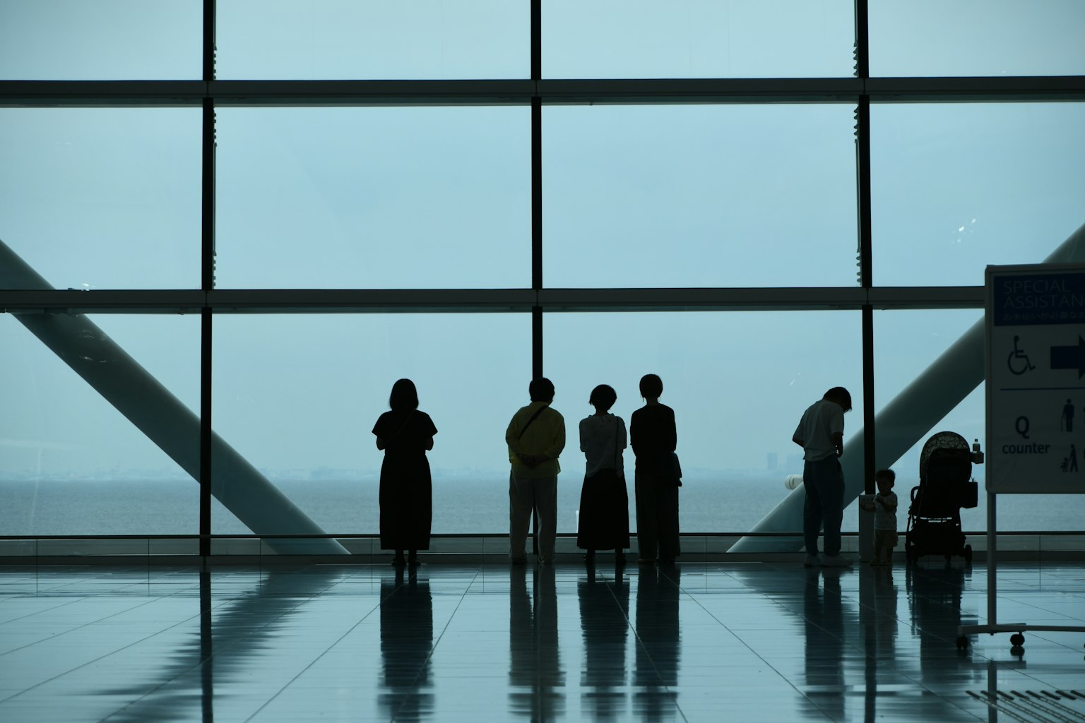 Silhouettes de personnes devant de grandes fenêtres d'aéroport