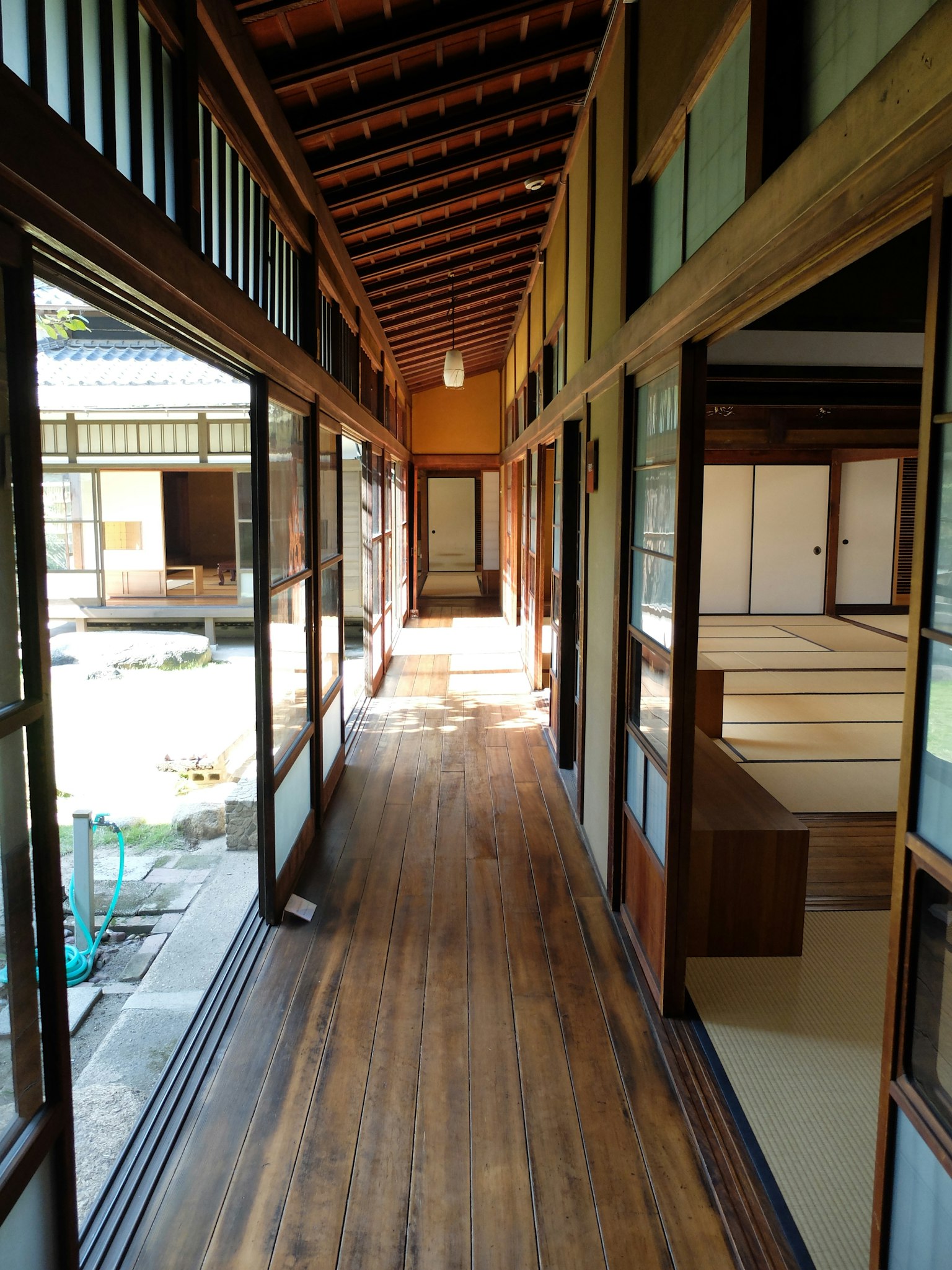 Koridor rumah tradisional Jepang dengan lantai kayu dan cahaya alami yang cerah