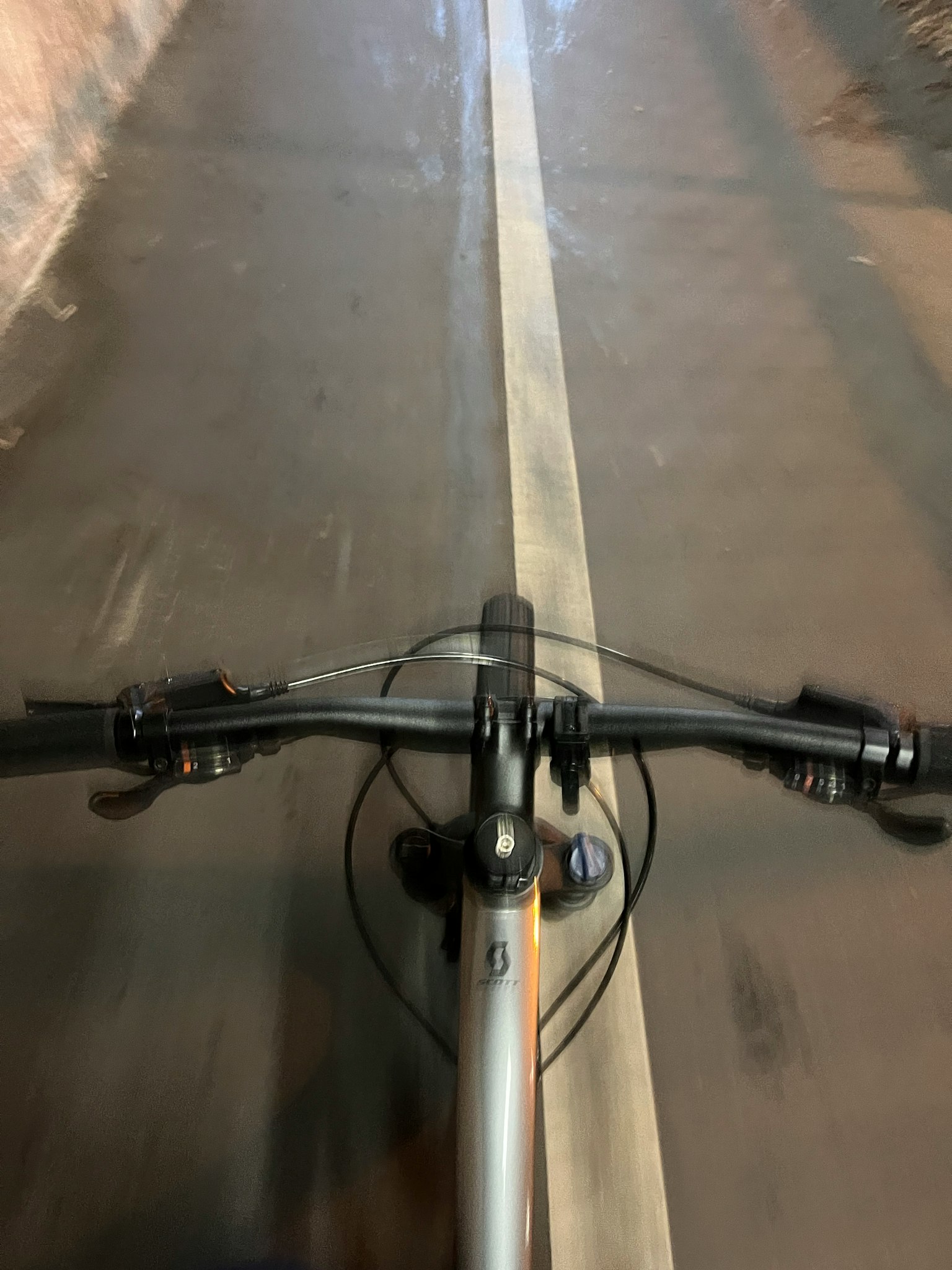 自転車のハンドルバーの視点から見た道の景色 速さを感じさせる動きのある画像