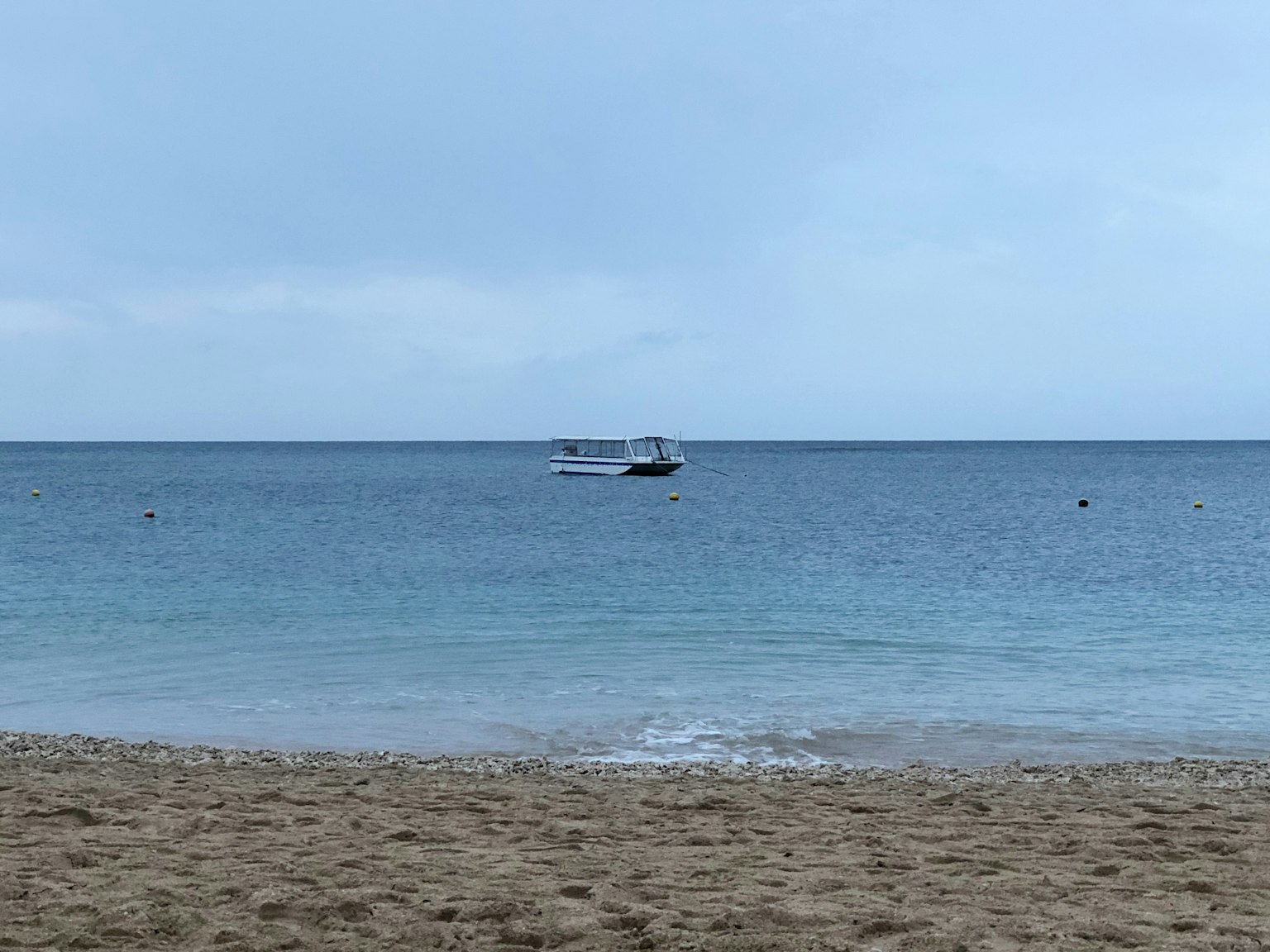 平静的海洋和沙滩风景 远处有一只小船