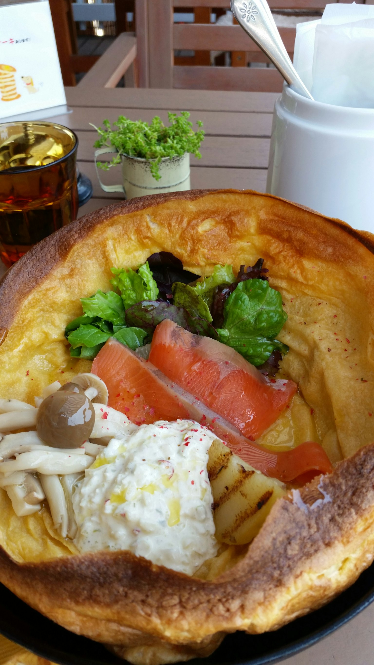Una grande ciotola di pane riempita con insalata, salmone affumicato, uovo e funghi