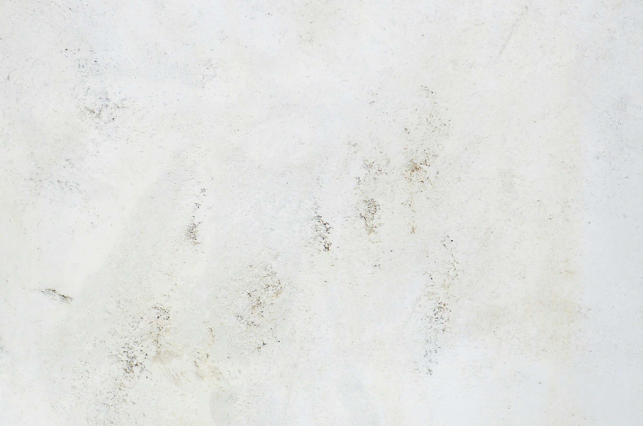 macchie consumate e texture su un muro bianco