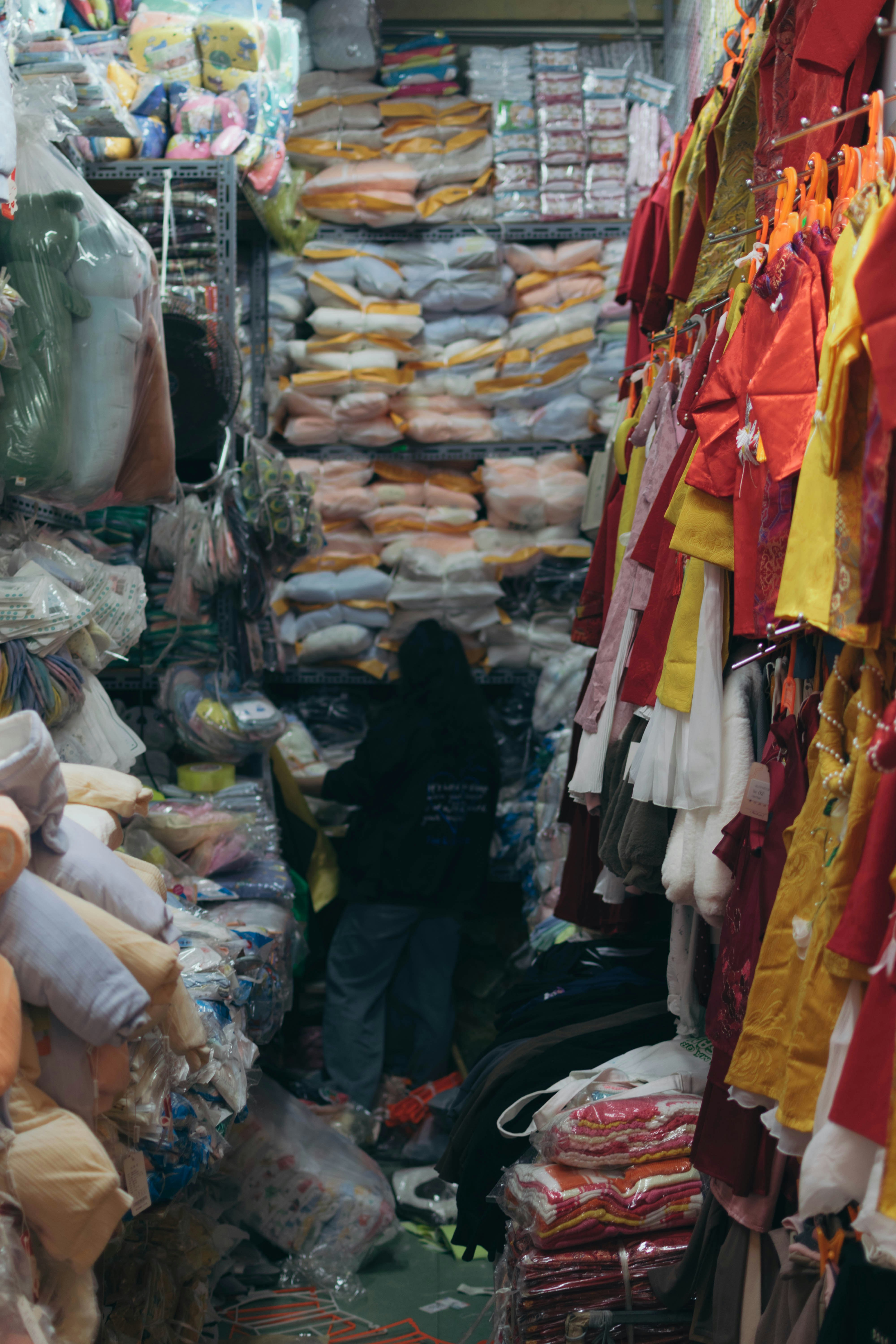 corridoio di mercato a Hanoi, Vietnam, con vestiti e merci impilati