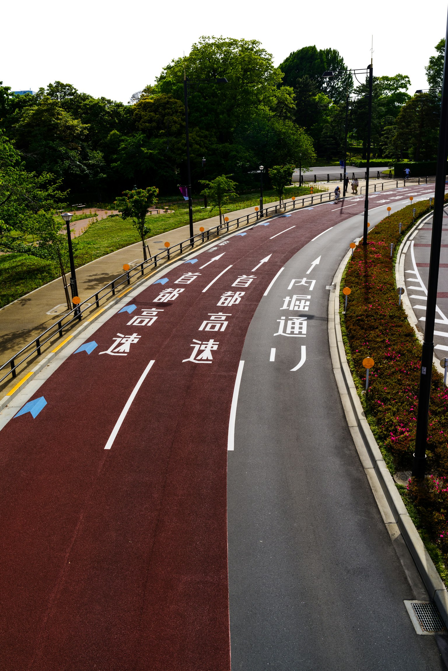 Carril bici con pavimento rojo y negro en un parque