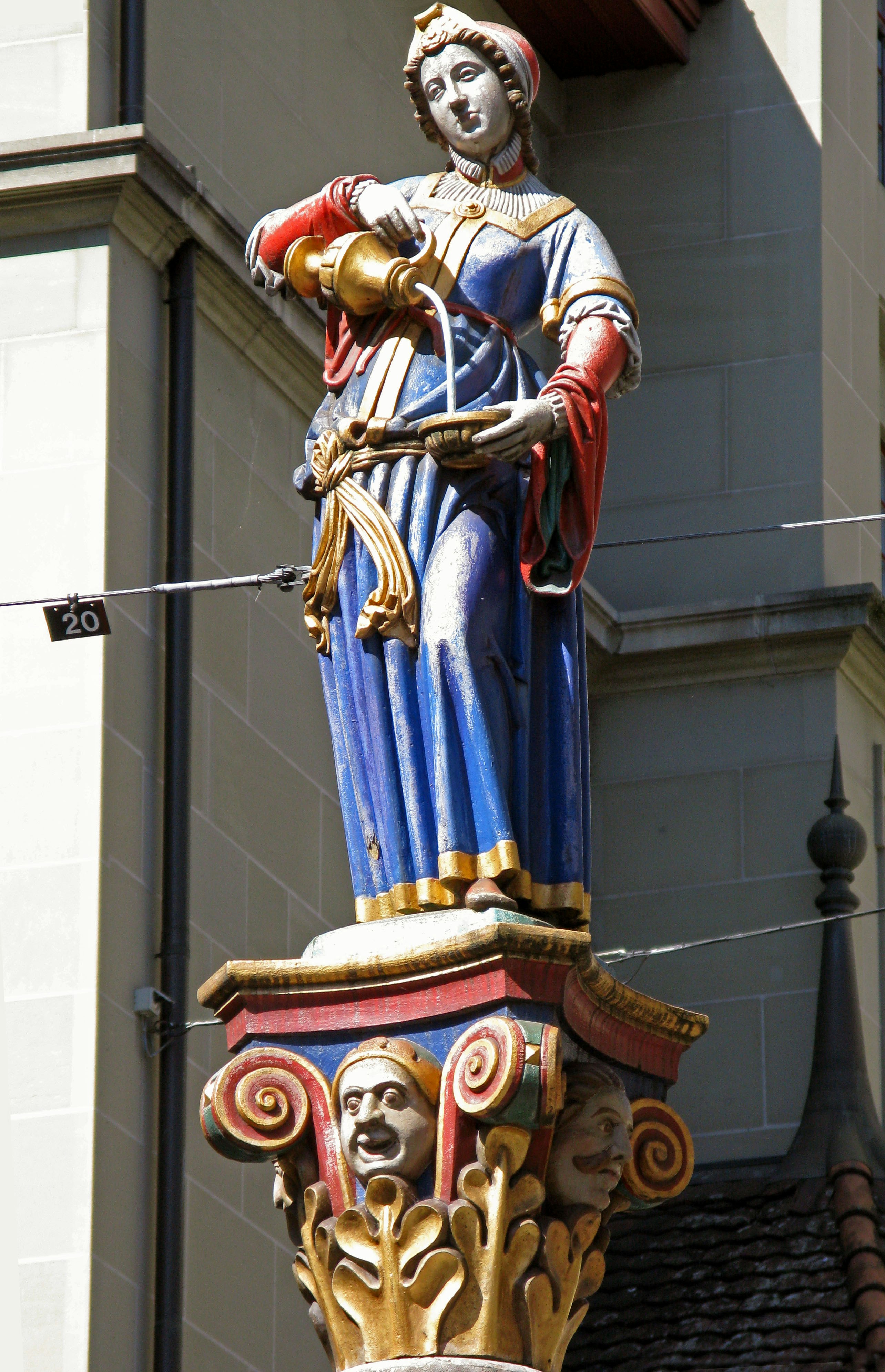 blue-and-white saint statue mounted on a building wall