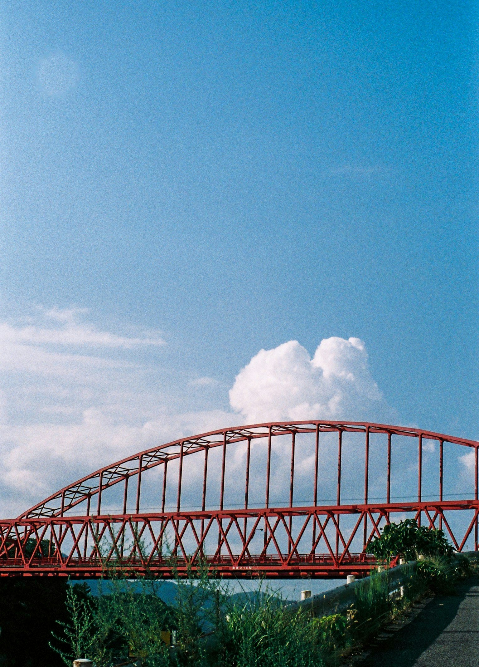 Vista di un ponte ad arco rosso contro un cielo blu