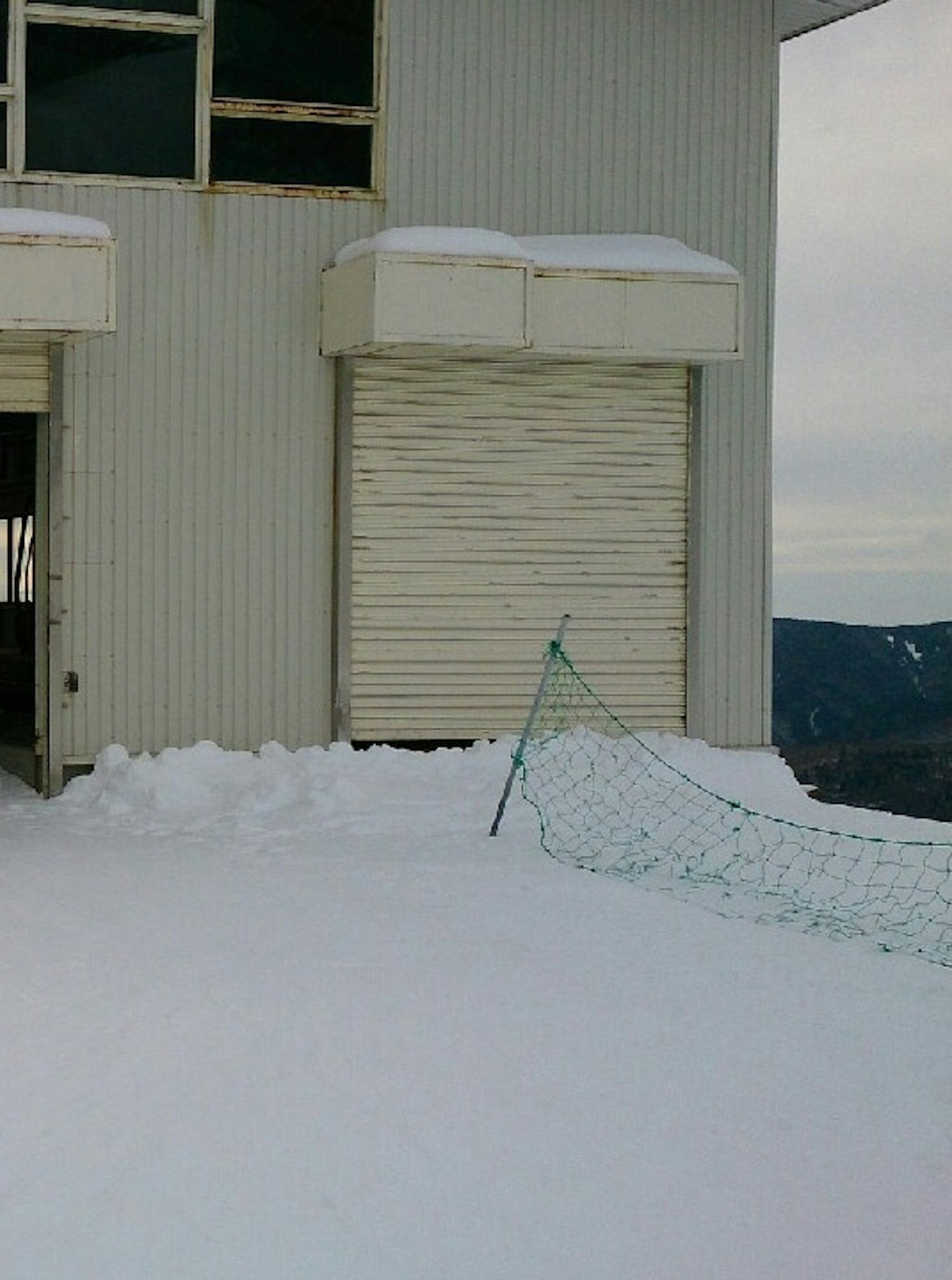 被雪覆盖的建筑侧面和关闭的卷帘门