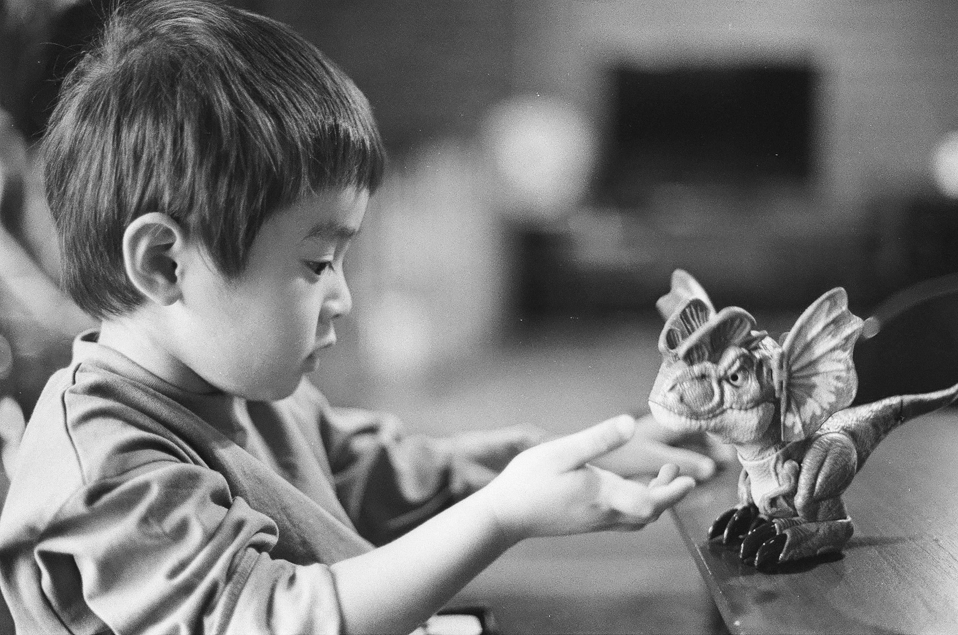 Enfant jouant à l’intérieur en tendant la main vers une petite figurine