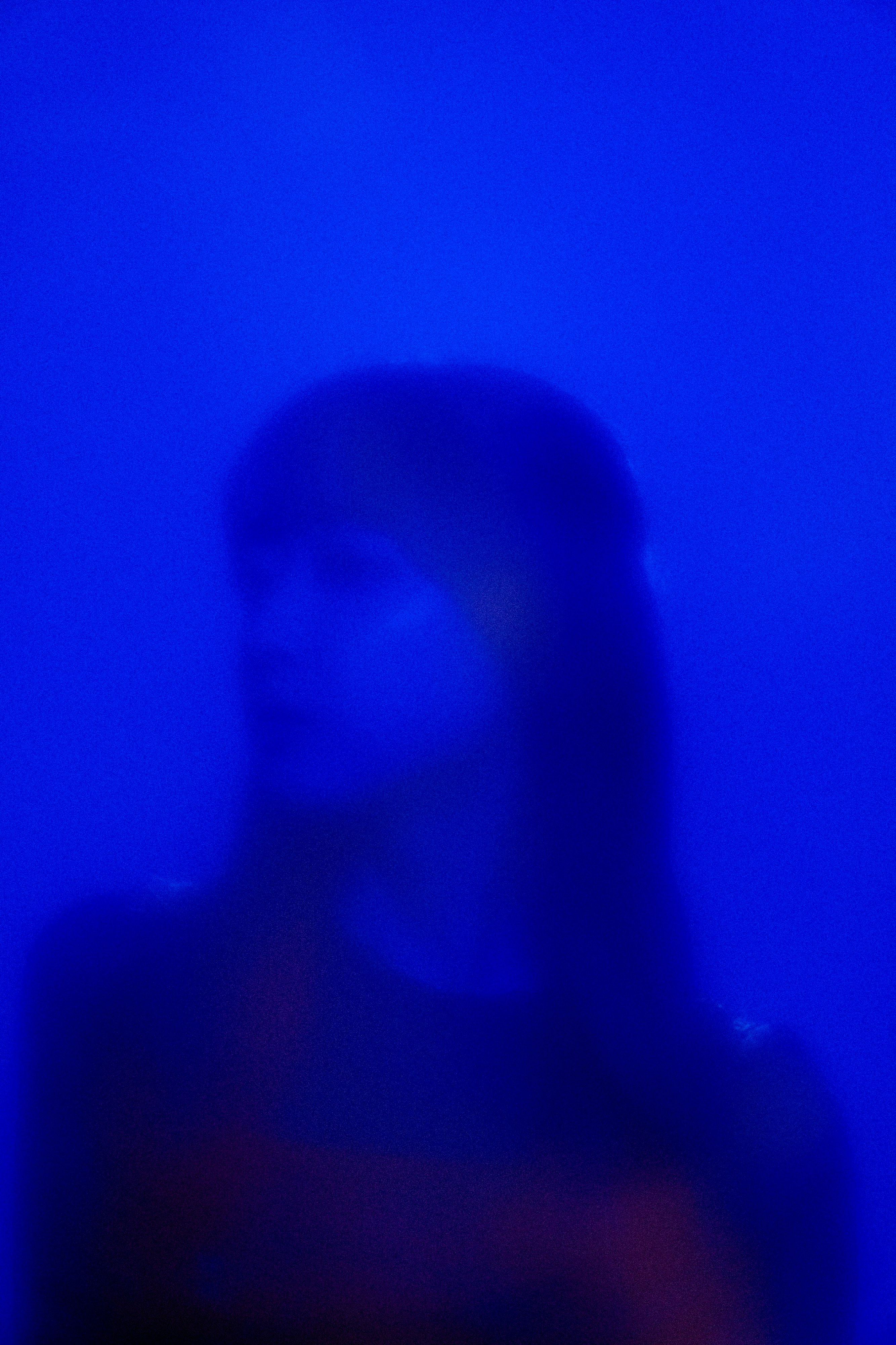 blurred person silhouette in blue lighting