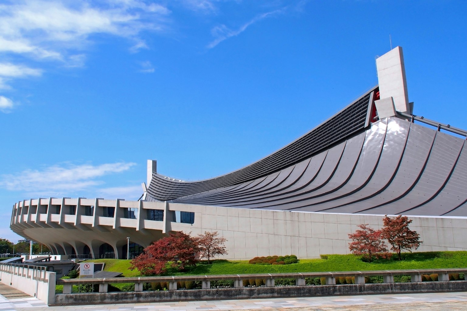 东京体育馆的特写现代建筑风格明亮的蓝天和绿色植物