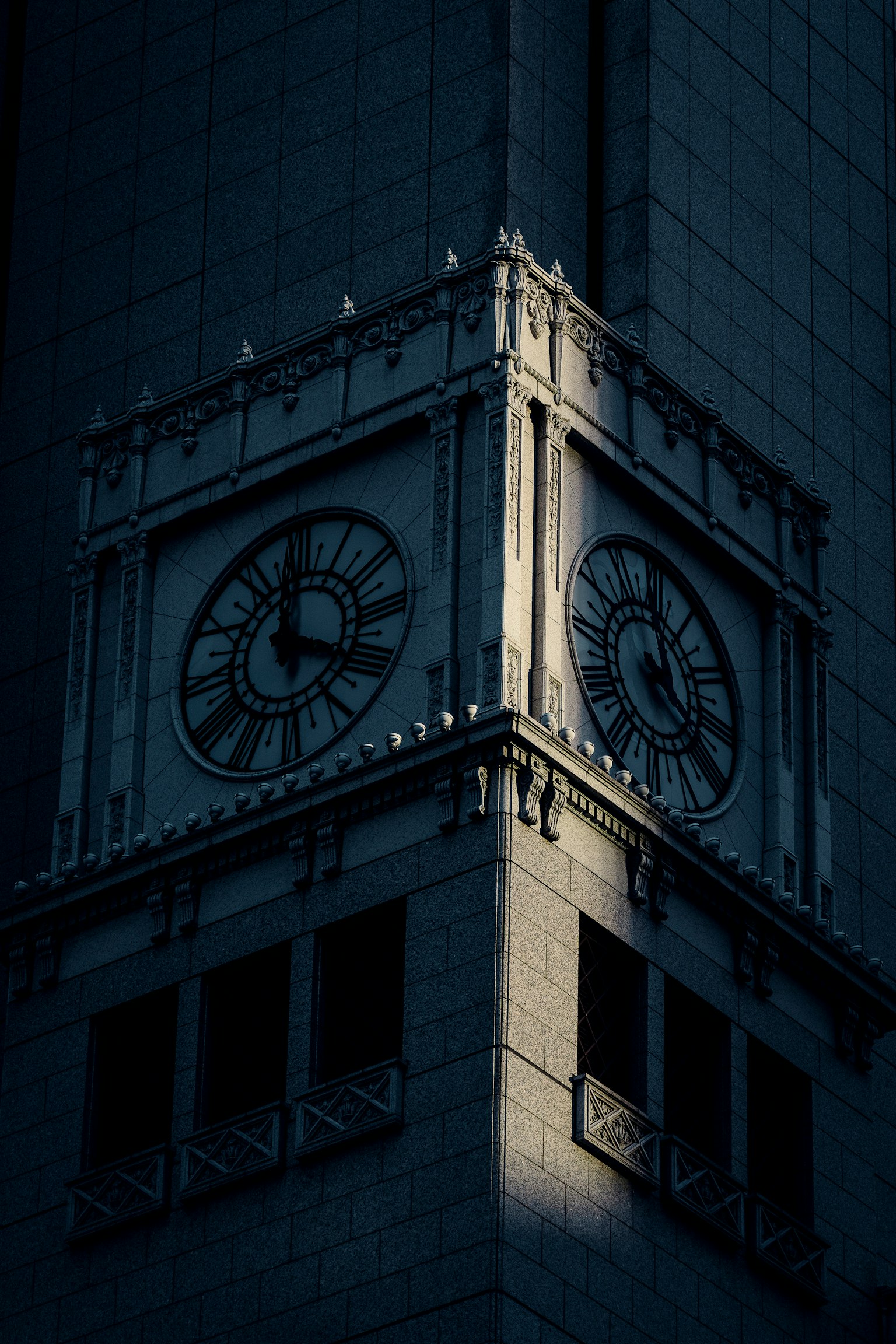 暗い背景に浮かぶ時計塔の一部が強調されている