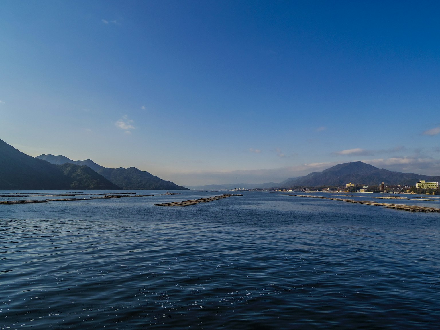 Malersicher Blick auf einen Fluss mit blauem Himmel und Bergen im Hintergrund