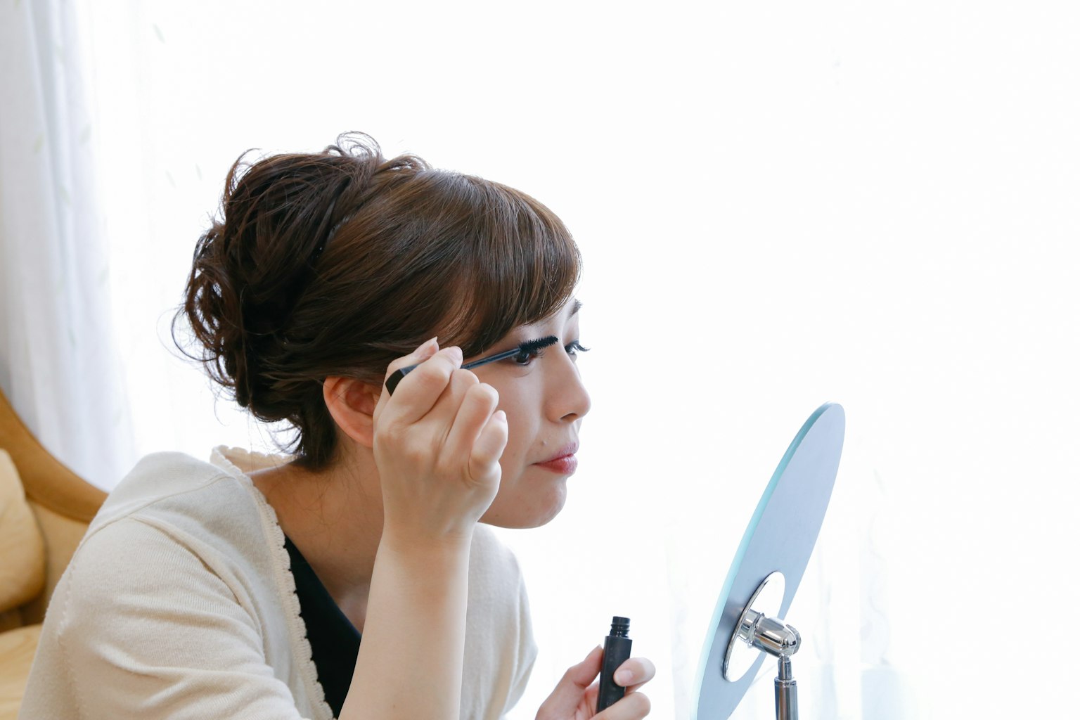 女性在镜子前化眼妆