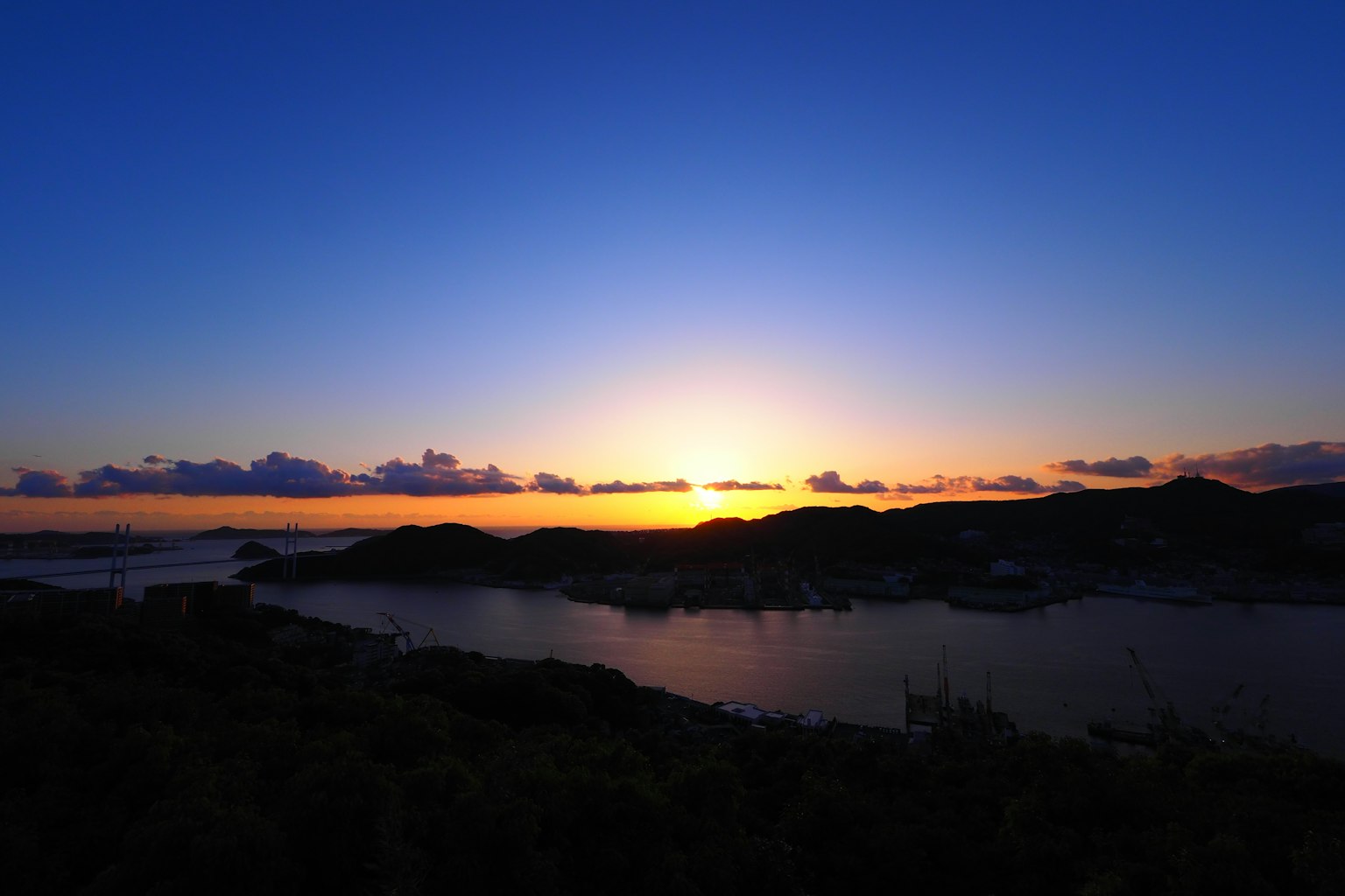 Beautiful sunset over the ocean with a blue sky and orange sunlight