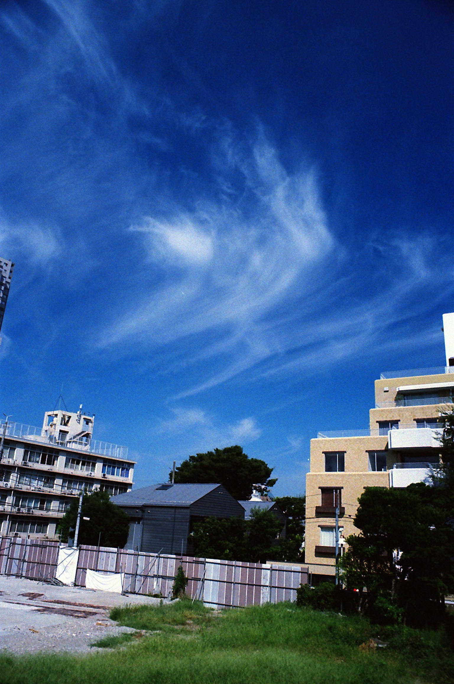 Paesaggio urbano con cielo blu e nuvole bianche, edifici vicini visibili