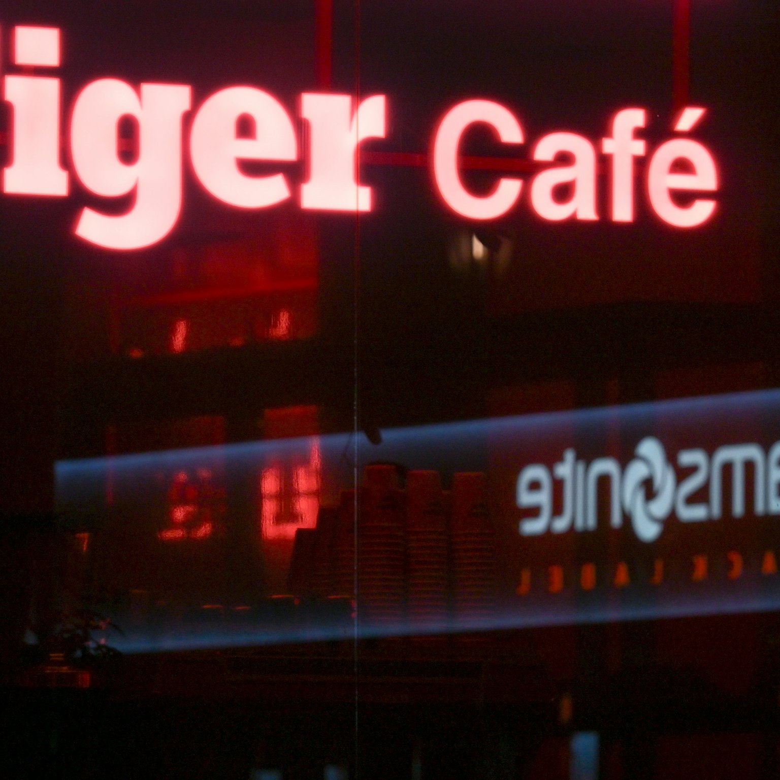 Exterior de un café con un letrero de neón rojo