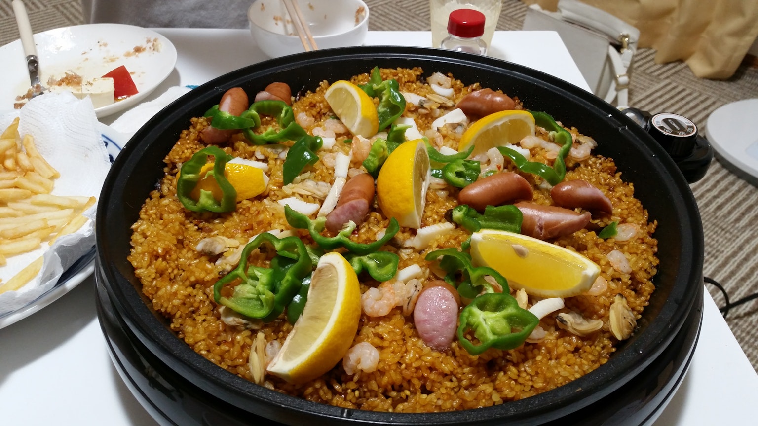 Piatto di paella colorato guarnito con limone e erbe