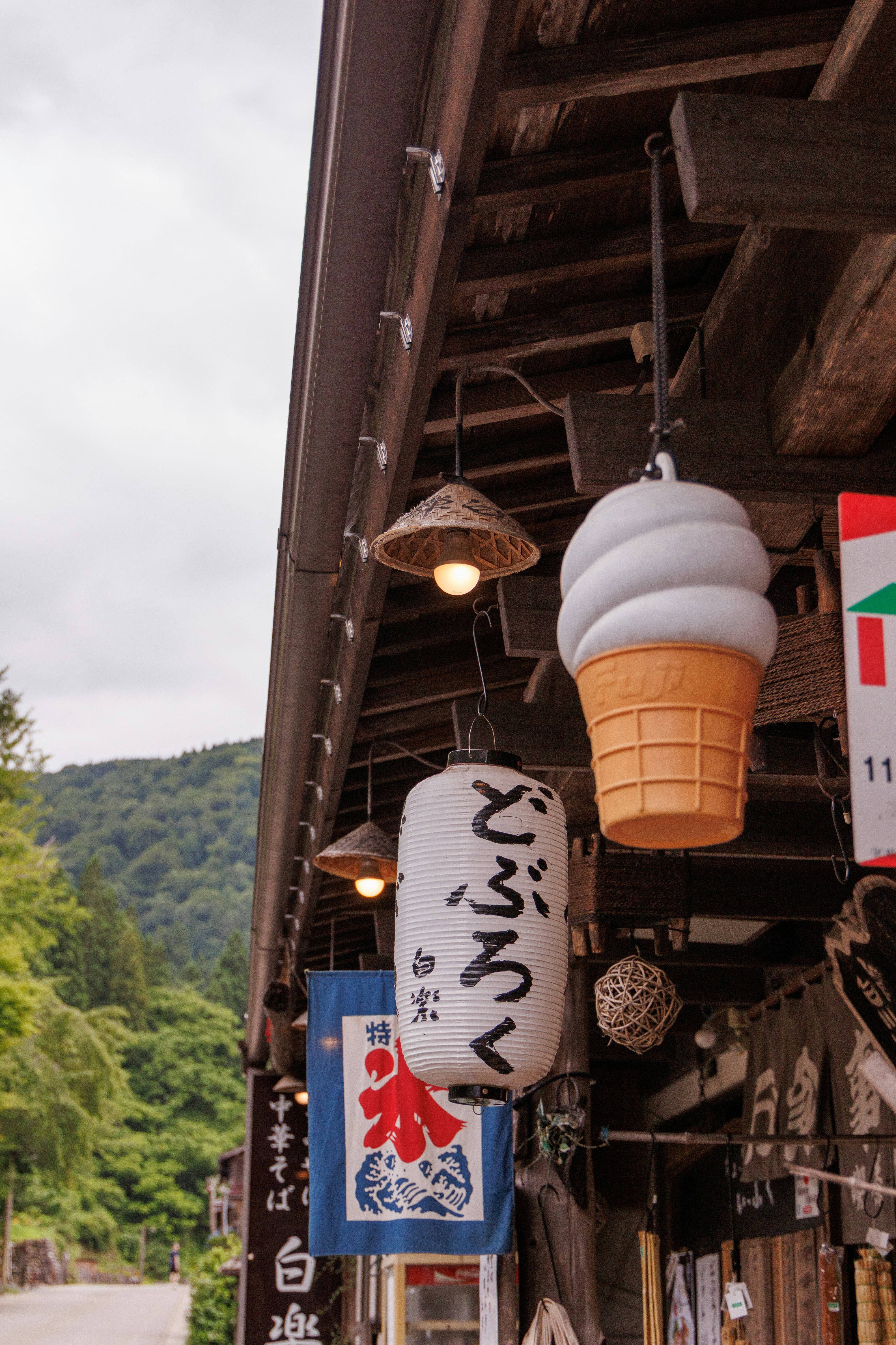 山あいの商店街で吊り下げられた提灯と看板のある軒先