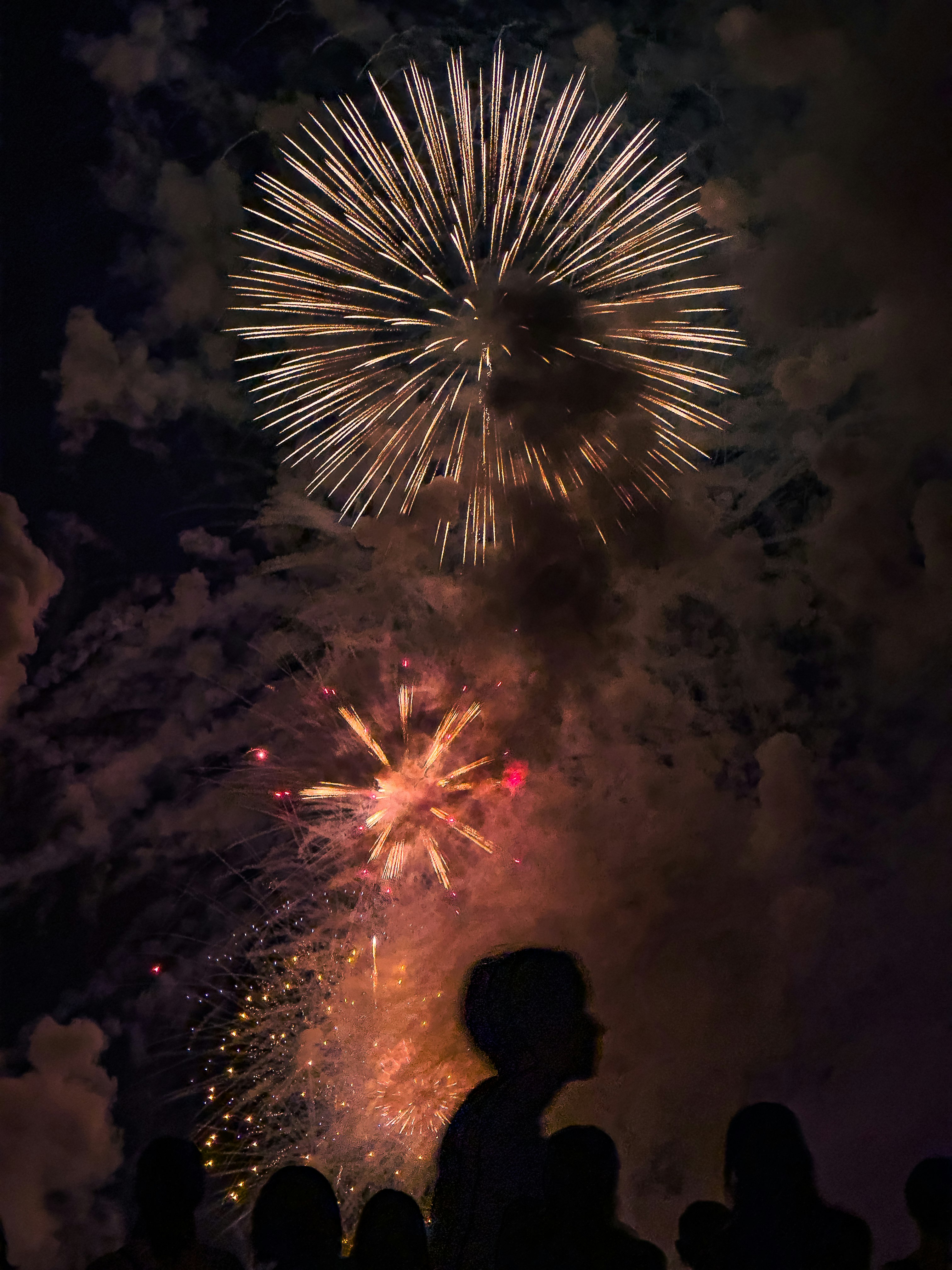 夜空に広がる花火の打ち上げと煙