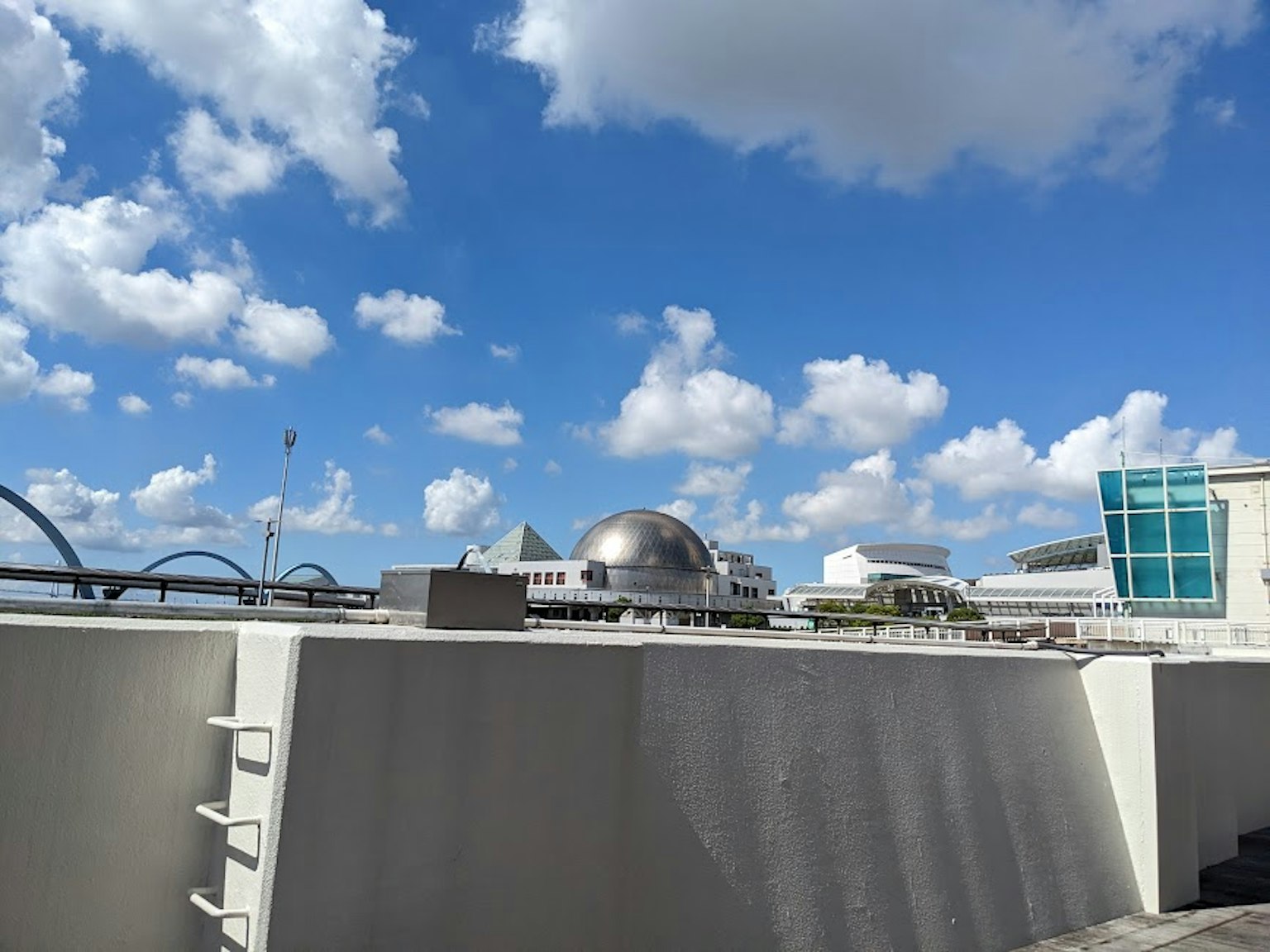 Bangunan modern dan struktur kubah di bawah langit biru