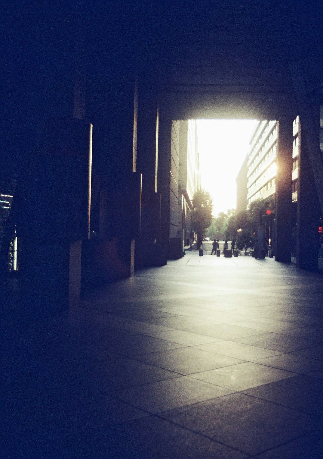 lorong berarkade dengan cahaya backlight saat senja