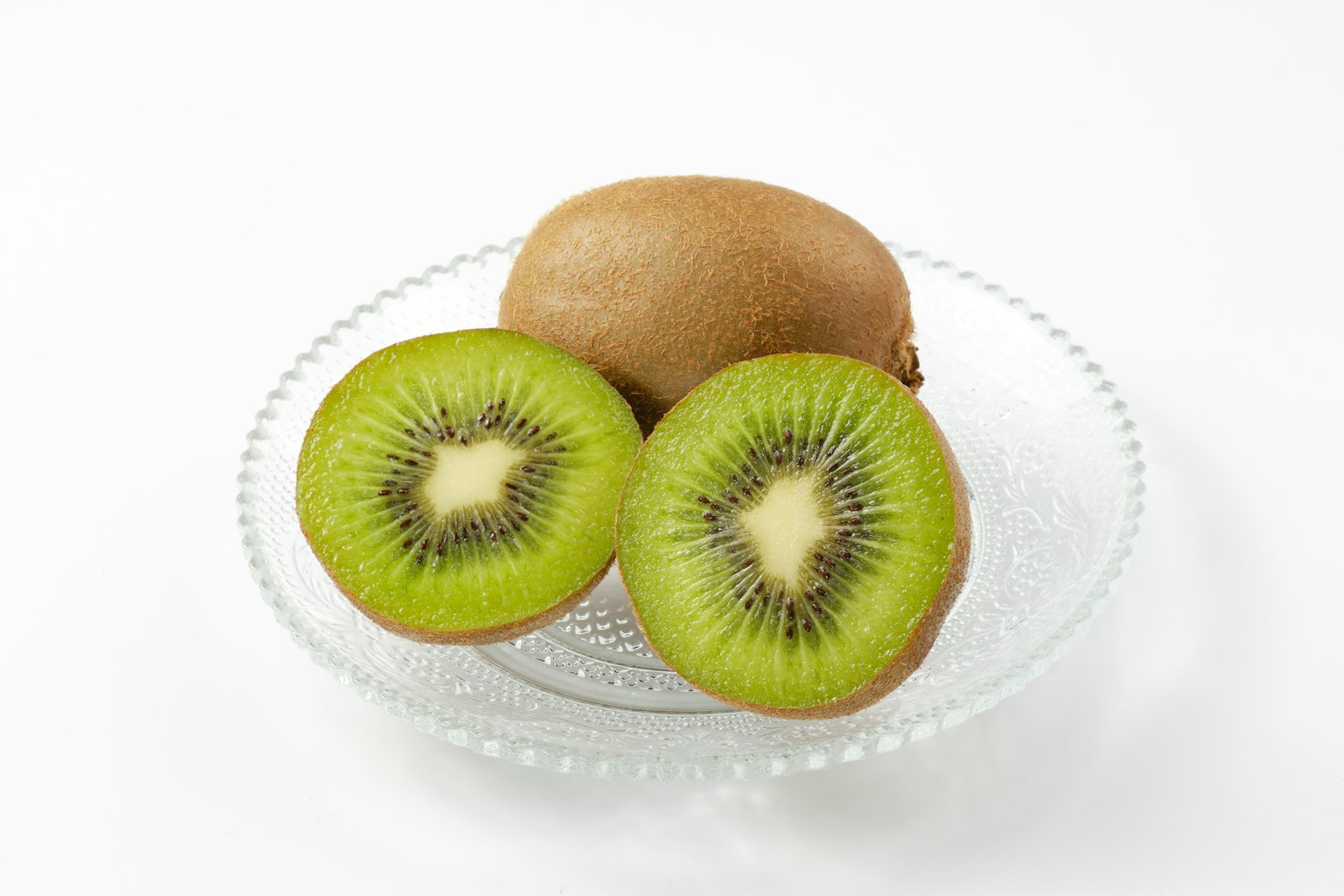 Kiwi intero e affettato su un piatto di vetro