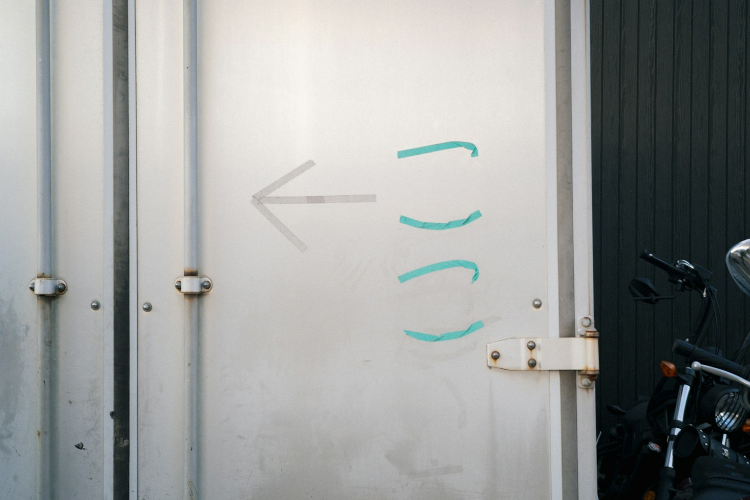金属製のドアに青い矢印と曲線のマークが描かれている