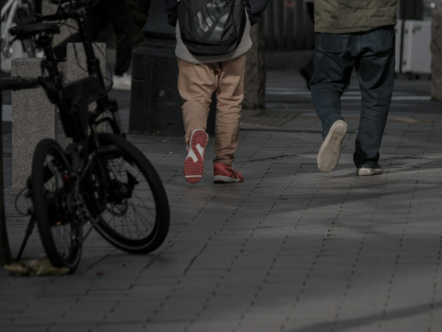 Scene of pedestrians walking with a bicycle parked nearby