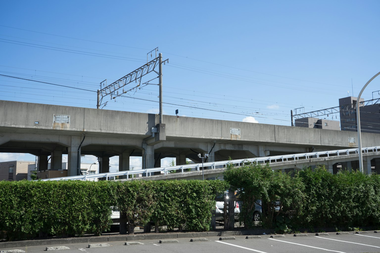 Urban landscape featuring an elevated road with blue sky and greenery below